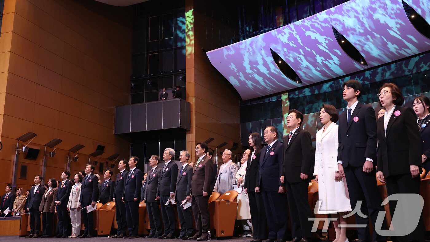 본문 이미지 - 이재명 대통령과 김혜경 여사가 1일 서울 강남구 코엑스에서 열린 제107주년 3·1절 기념식에서 애국가를 부르고 있다. 2026.3.1 ⓒ 뉴스1 이재명 기자