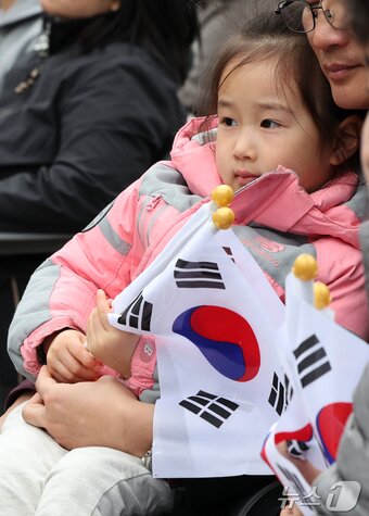 본문 이미지 - 1일 서울 종로구 보신각에서 열린 제107주년 3·1절 기념 타종행사에서 태극기를 든 한 어린이가 행사를 지켜보고 있다. 2026.3.1 ⓒ 뉴스1 김진환 기자
