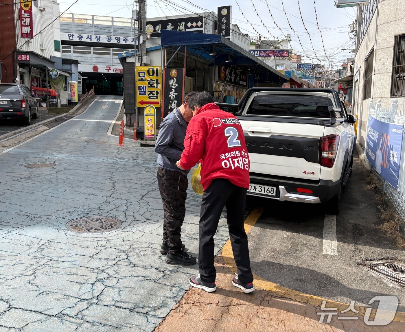 본문 이미지 - 경기 평택을 재선거에 출사표를 던진 국민의힘 이재영 후보가 평택읍 안중시장에서 시민들에게 명함을 나눠 주고 있다. 2026.02.26 ⓒ 뉴스1 홍유진 기자