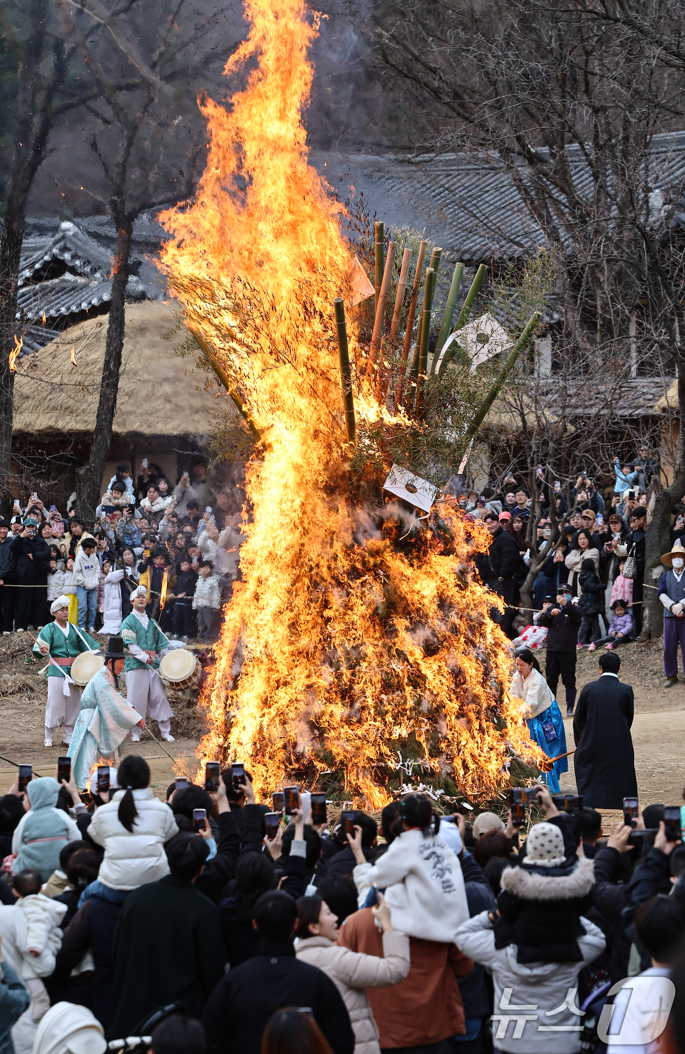 (용인=뉴스1) 김도우 기자 = 정월대보름을 이틀 앞둔 1일 경기 용인시 기흥구 한국민속촌에서 열린 달집태우기 행사에서 시민들이 타오르는 달집을 바라보며 소원을 빌고 있다. 202 …