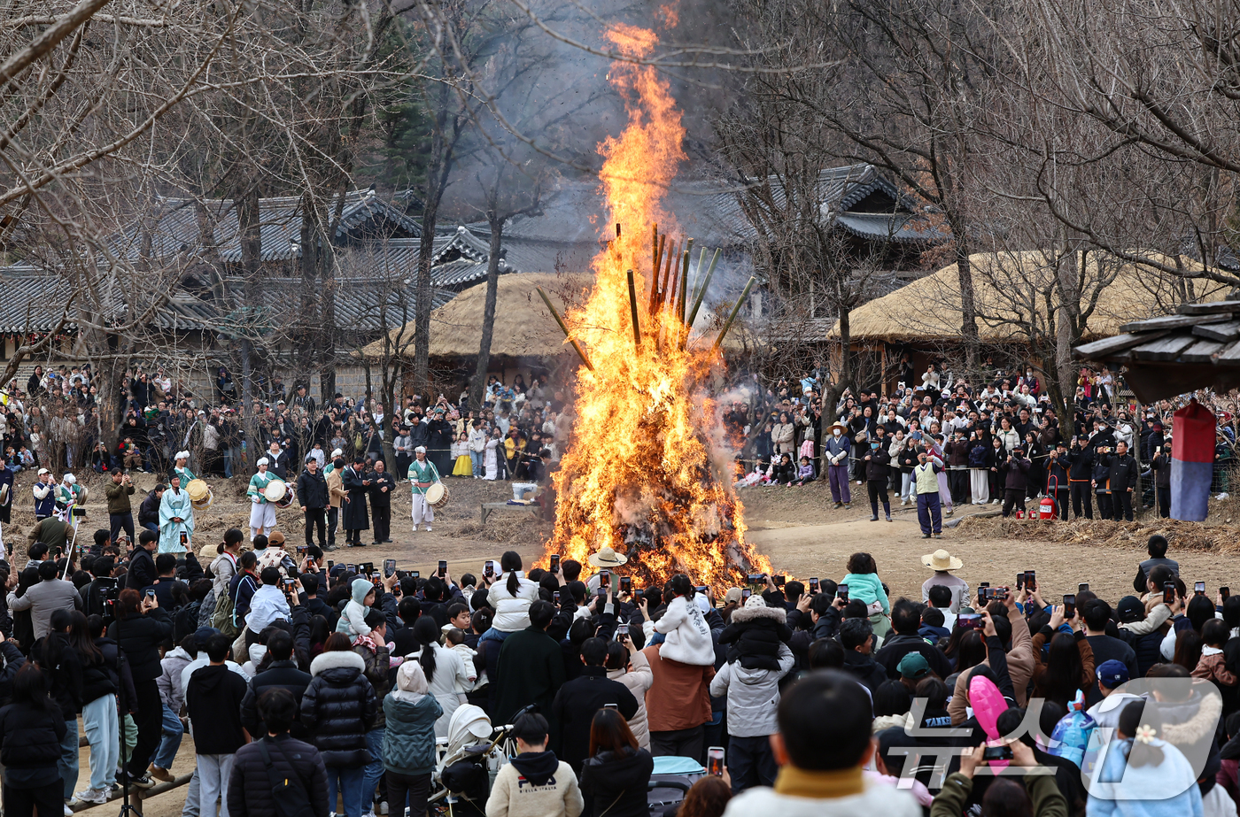 (용인=뉴스1) 김도우 기자 = 정월대보름을 이틀 앞둔 1일 경기 용인시 기흥구 한국민속촌에서 열린 달집태우기 행사에서 시민들이 타오르는 달집을 바라보며 소원을 빌고 있다. 202 …