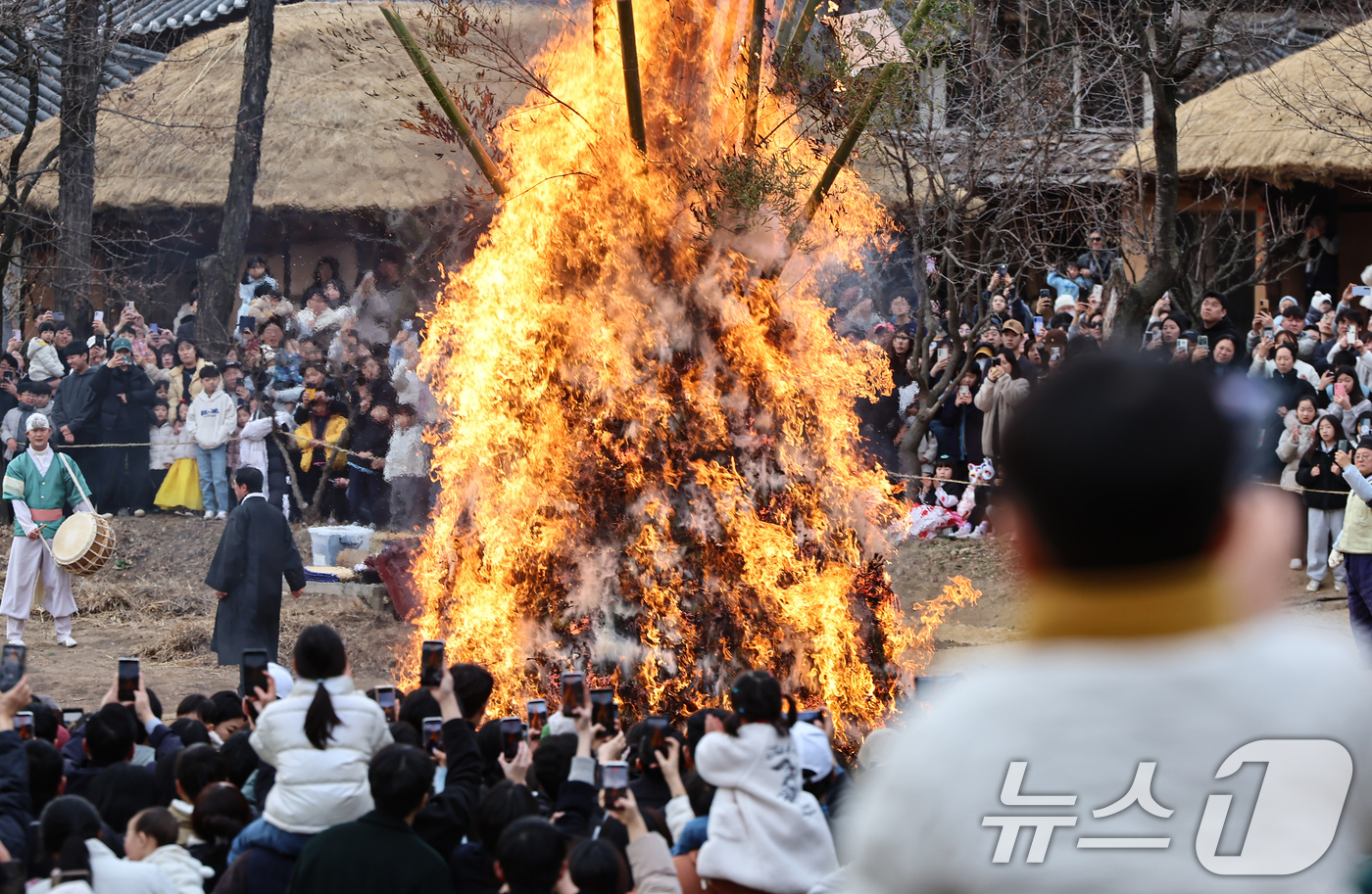 (용인=뉴스1) 김도우 기자 = 정월대보름을 이틀 앞둔 1일 경기 용인시 기흥구 한국민속촌에서 열린 달집태우기 행사에서 시민들이 타오르는 달집을 바라보며 소원을 빌고 있다. 202 …