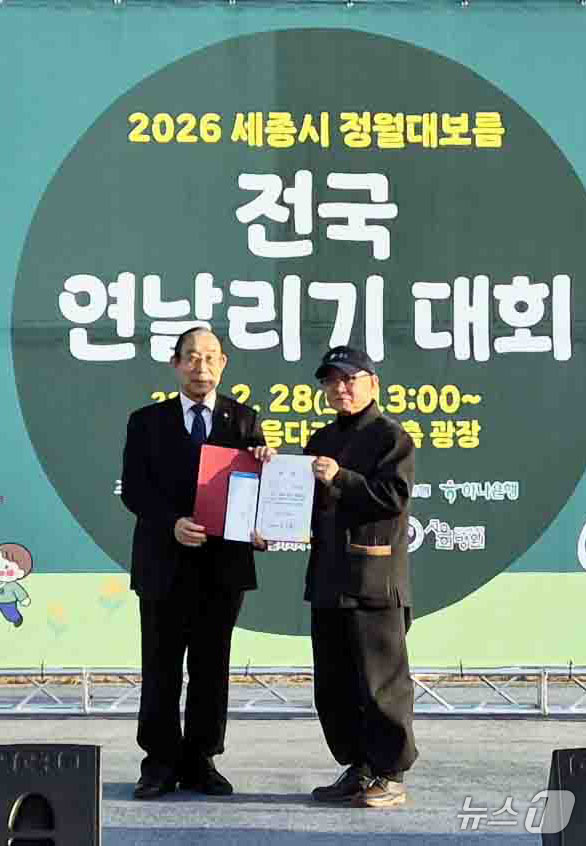 (서울=뉴스1) = 임창철 세종문화원장이 지난달 28일 세종시 이응다리 일원에서 열린 2026년 정월대보름 전국 연날리기 대회 창작연날리기 부문에서 은상을 수상한 강연중 씨에게 시 …