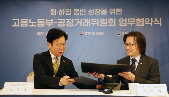 업무협약서 교환하는 김영훈 장관·주병기 위원장