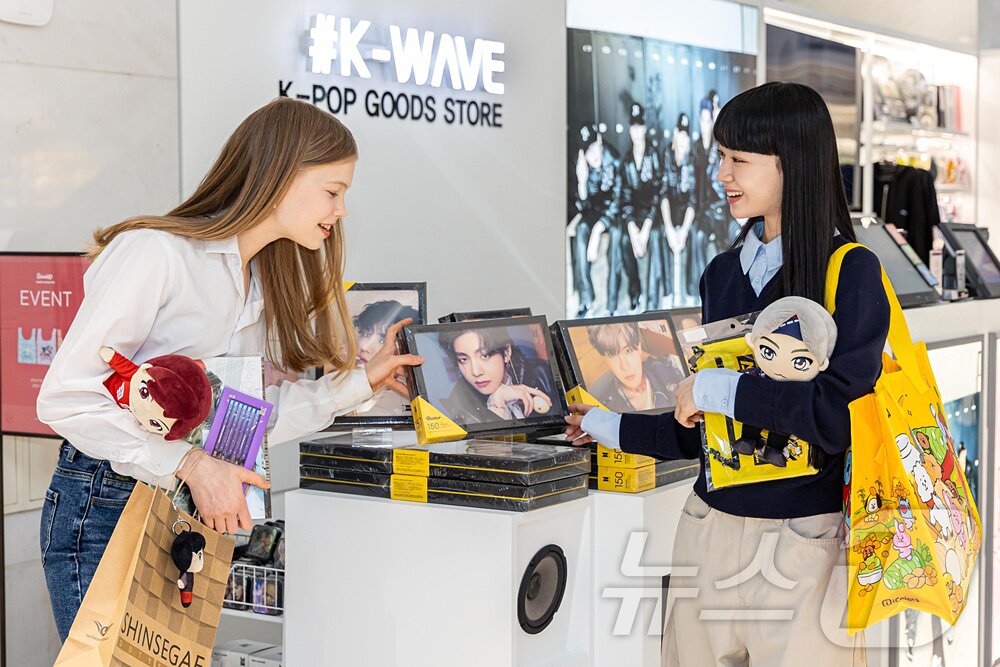 본문 이미지 - 사진은 외국인 모델들이 신세계면세점 명동점 'K-WAVE 존'에서 BTS 굿즈를 살펴보는 모습. (신세계면세점 제공. 재판매 및 DB 금지) 2026.3.11 ⓒ 뉴스1