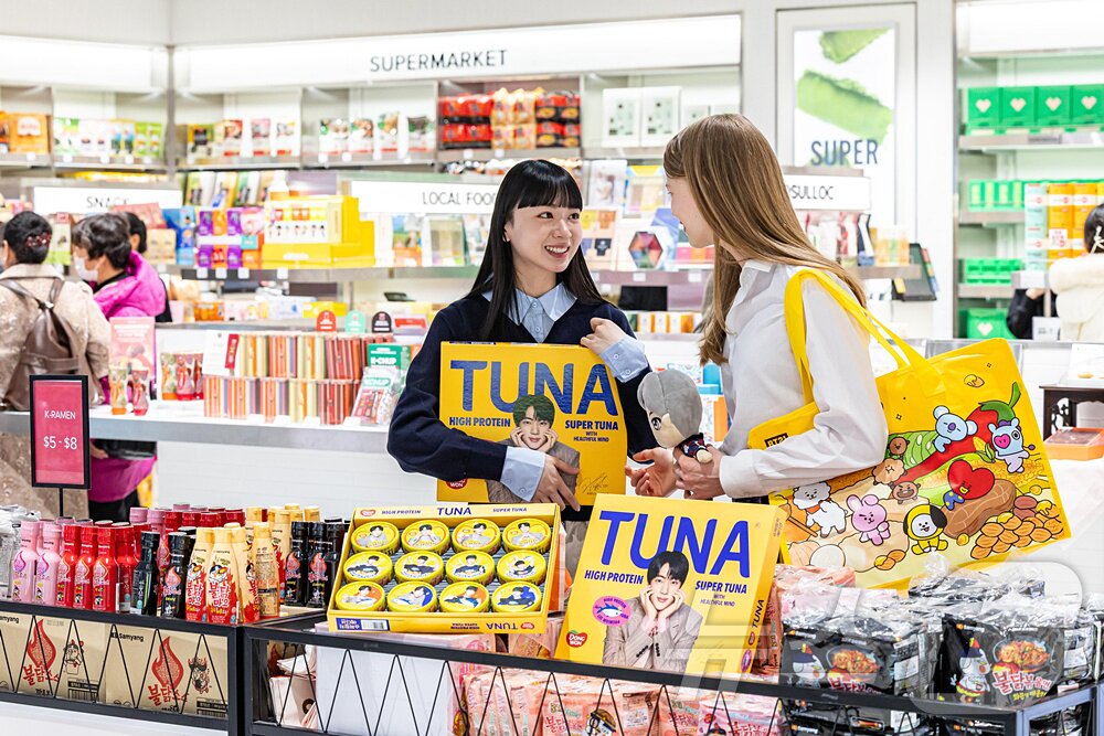 본문 이미지 - 사진은 외국인 모델들이 신세계면세점 명동점 미식 큐레이션 공간 ‘테이스트 오브 신세계’에서 동원F&B와 방탄소년단 멤버 진이 협업한 ‘동원 슈퍼참치 에디션 선물세트’를 살펴보는 모습. (신세계면세점 제공. 재판매 및 DB 금지) 2026.3.11 ⓒ 뉴스1
