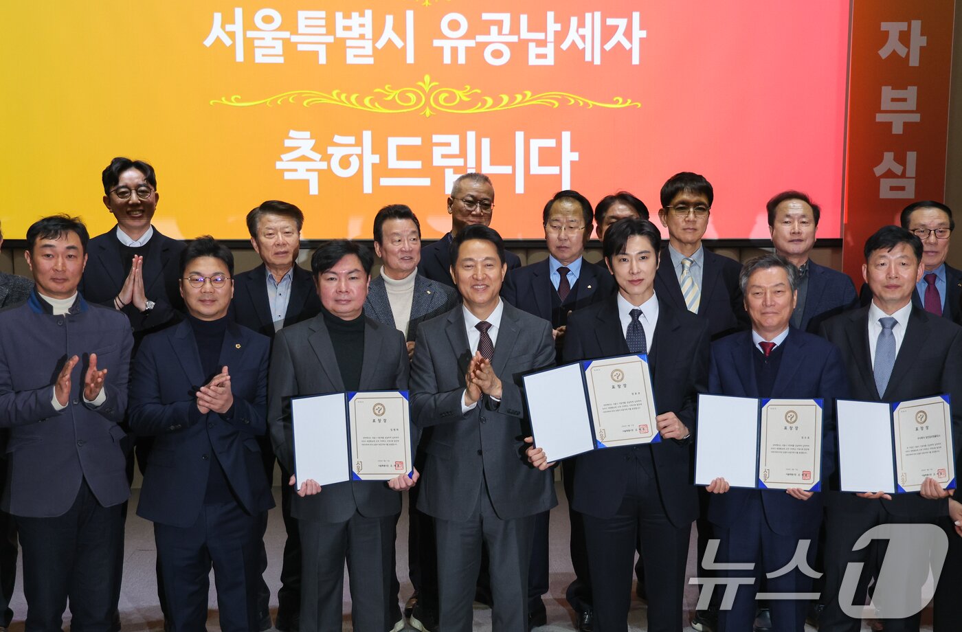 본문 이미지 - 오세훈 서울시장이 11일 오전 시청에서 열린 2026년 유공납세자 표창장 수여식에 참석해 가수 겸 배우 정윤호, 배우 임원희를 비롯한 유공납세자들에게 표창장을 수여한 뒤 기념 촬영을 하고 있다. 2026.3.11 ⓒ 뉴스1 안은나 기자