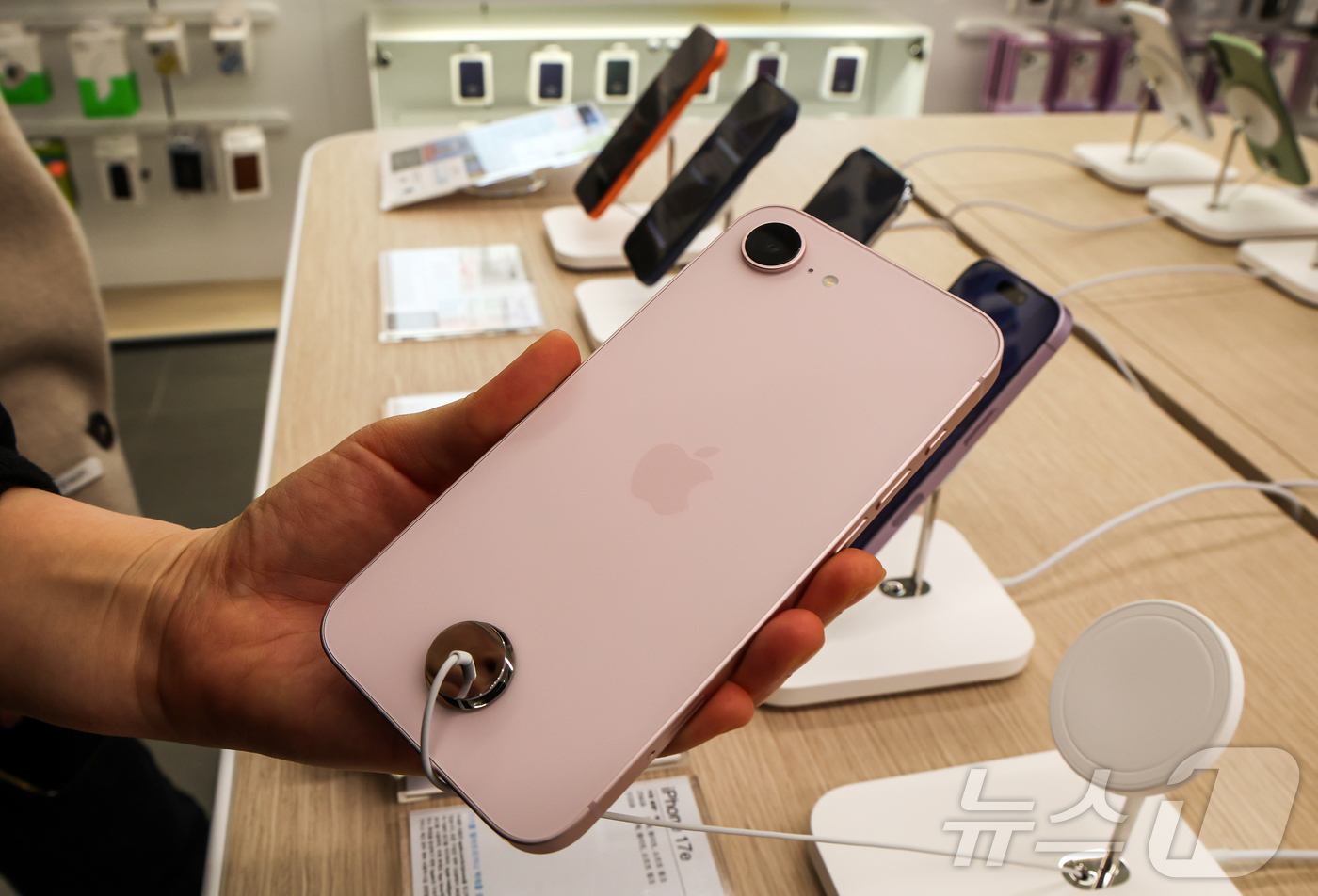 (서울=뉴스1) 김진환 기자 = 11일 서울 서초구 프리스비 신세계 강남점을 찾은 방문객이 이날 공식 출시된 애플의 보급형 모델 '아이폰 17e'를 둘러보고 있다. 2026.3.1 …