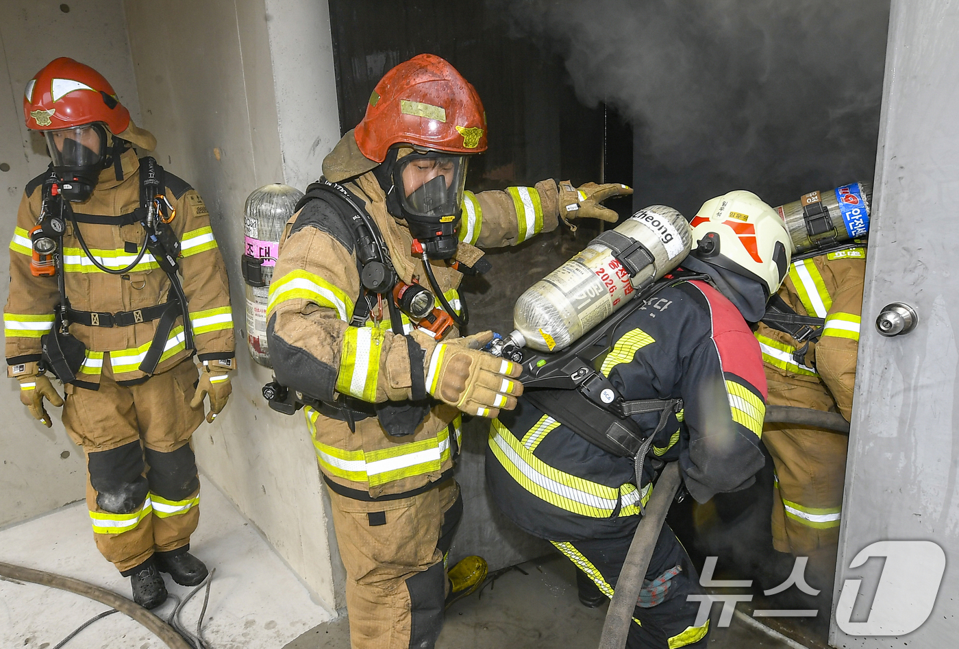 (용인=뉴스1) 김영운 기자 = 11일 경기 용인시 처인구 경기도소방학교에서 소방대원들이 구획실 화재진압 훈련을 위해 실제 화재 상황을 재현한 훈련장 내부로 진입하고 있다. (공동 …