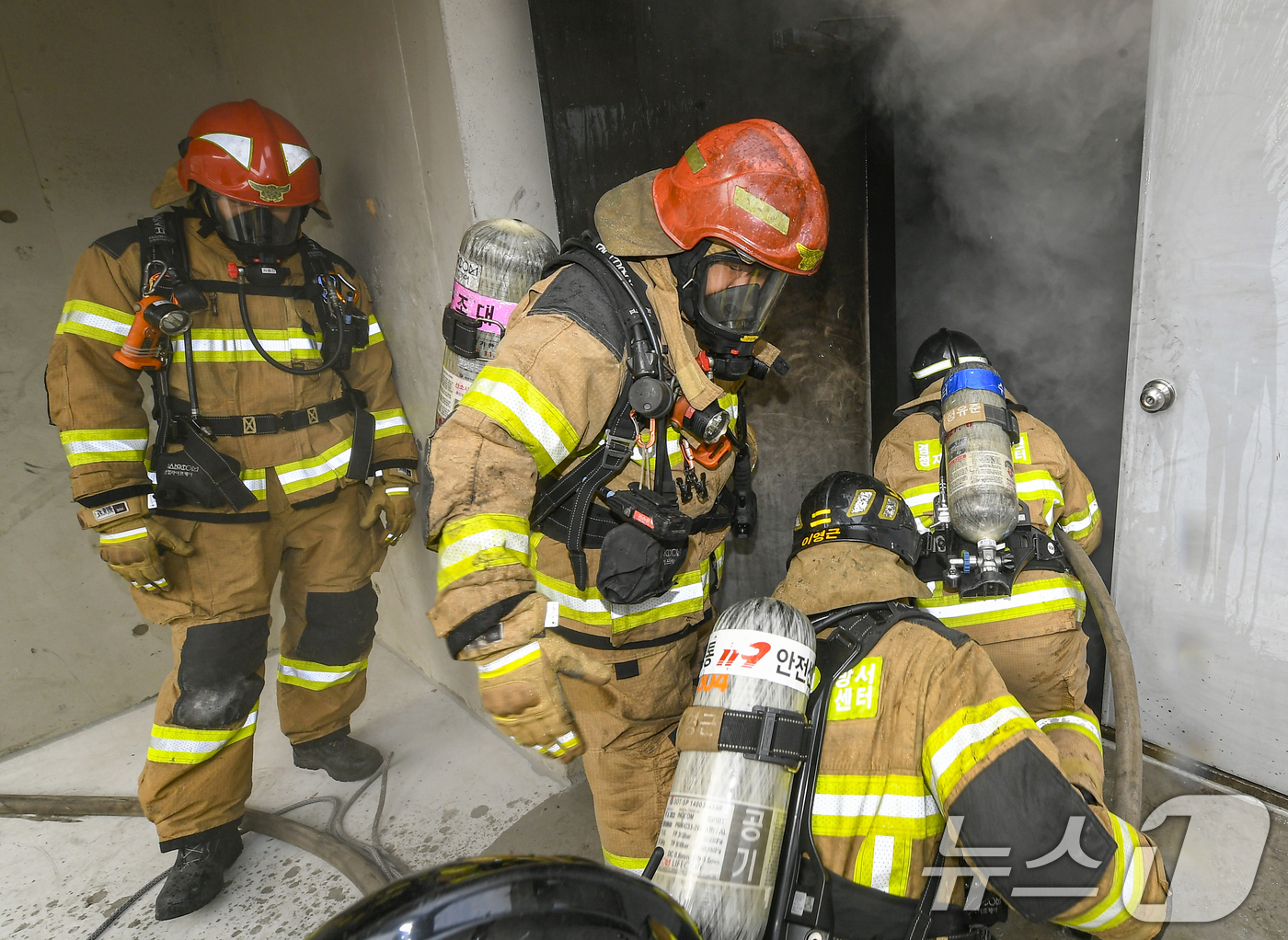(용인=뉴스1) 김영운 기자 = 11일 경기 용인시 처인구 경기도소방학교에서 소방대원들이 구획실 화재진압 훈련을 위해 실제 화재 상황을 재현한 훈련장 내부로 진입하고 있다. (공동 …