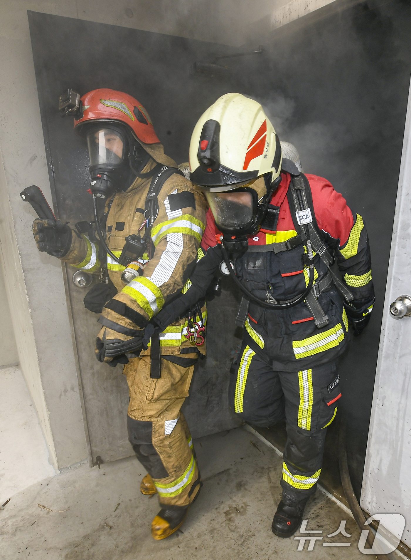 (용인=뉴스1) 김영운 기자 = 11일 경기 용인시 처인구 경기도소방학교에서 소방대원들이 구획실 화재진압 훈련을 마치고 실제 화재 상황을 재현한 훈련장에서 나오고 있다. (공동취재 …