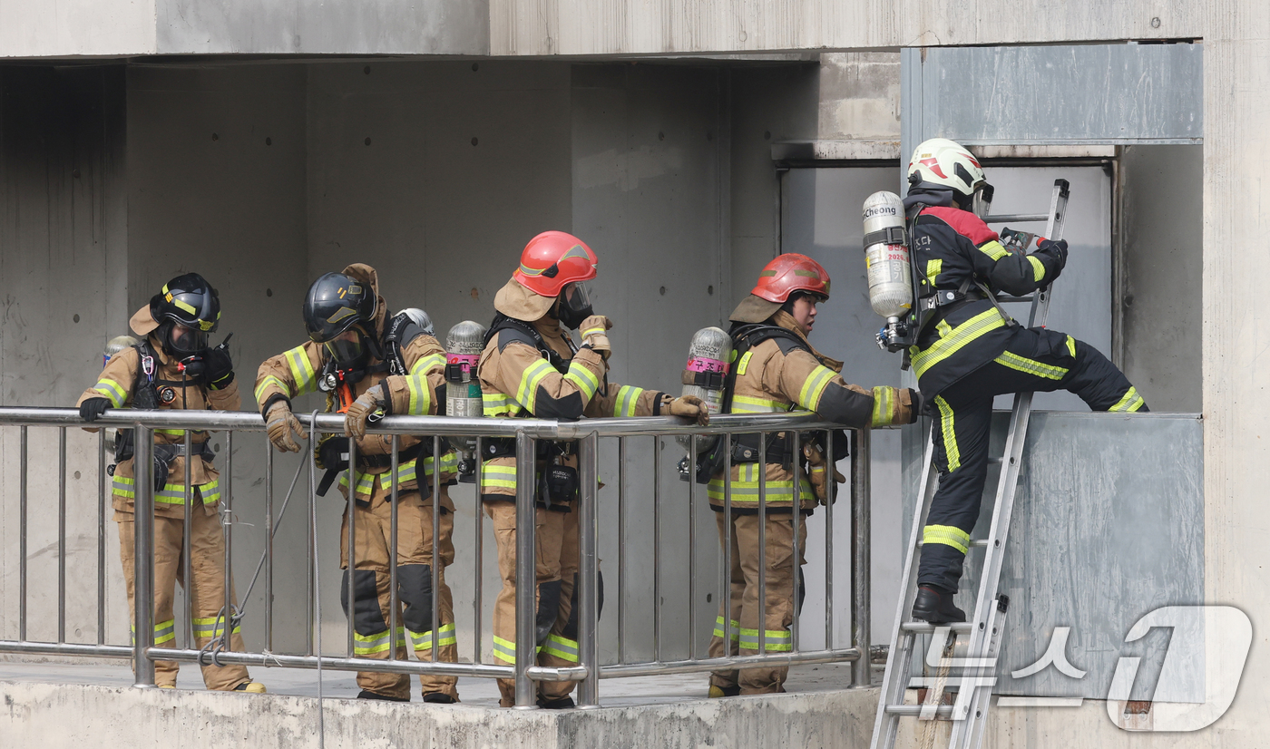 (용인=뉴스1) 김영운 기자 = 11일 경기 용인시 처인구 경기도소방학교에서 소방대원들이 구획실 화재진압 훈련을 위해 실제 화재 상황을 재현한 훈련장 내부로 진입하고 있다. 202 …