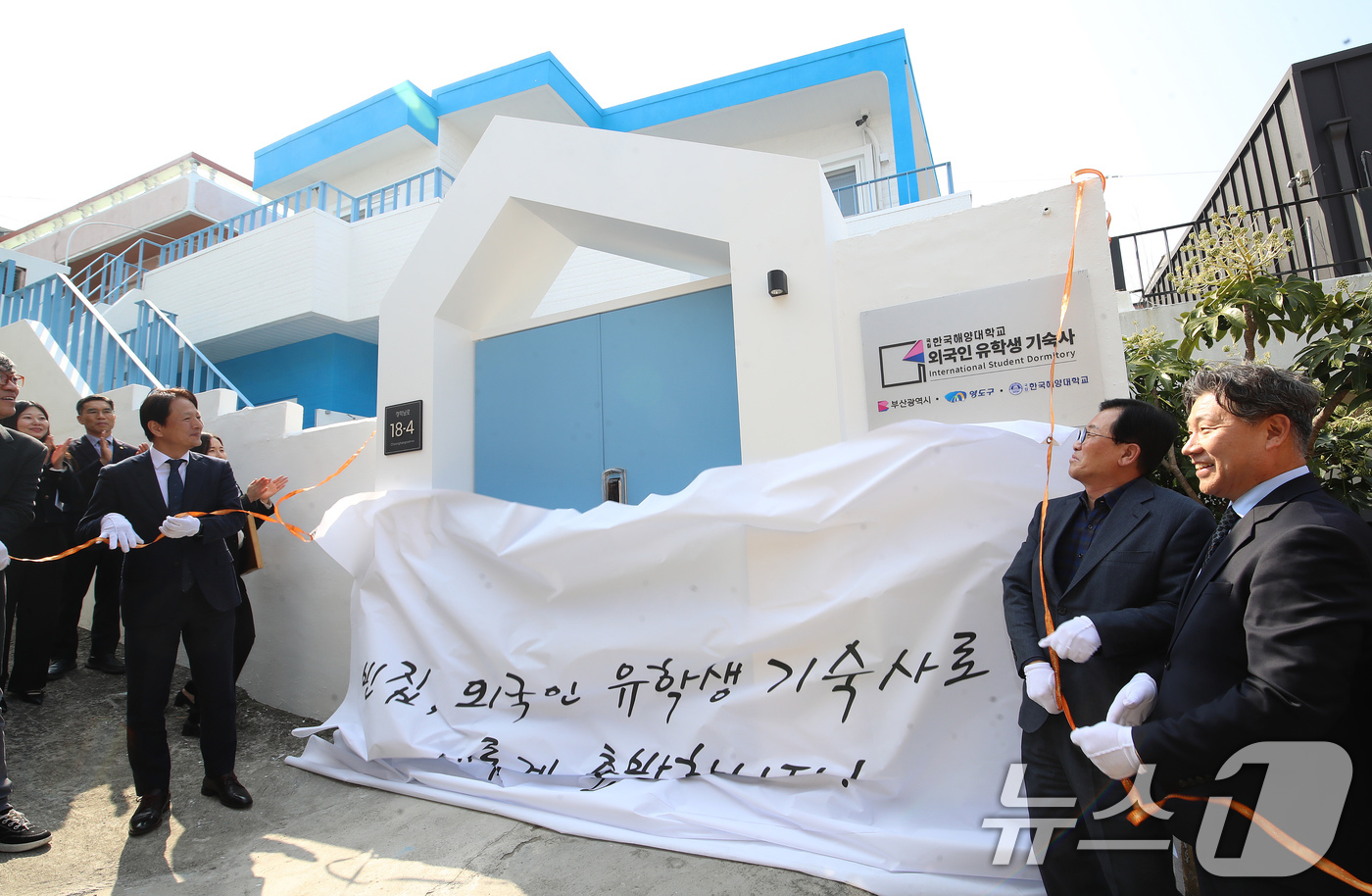 (부산=뉴스1) 윤일지 기자 = 11일 오후 부산 영도구 청학동 일대에서 열린 국립한국해양대학교 외국인 유학생 기숙사 입주식에서 참석자들이 현판식을 하고 있다.이 기숙사는 도심에 …