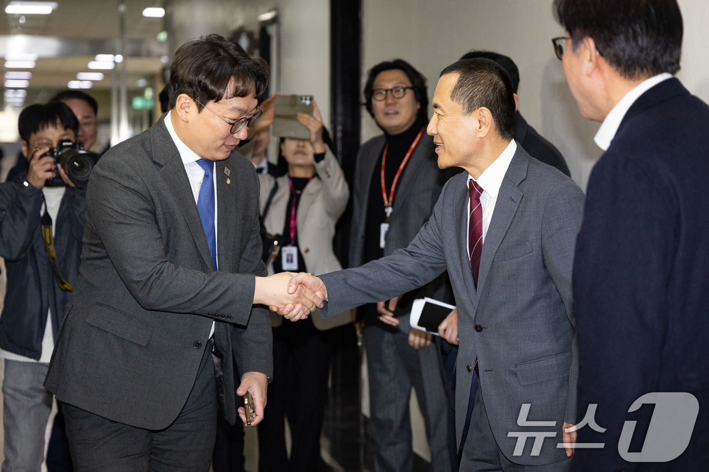 (서울=뉴스1) 유승관 기자 = 김진태 강원도지사와 모경종 더불어민주당 의원이 11일 서울 여의도 국회 행정안전위원회 회의장 앞에서 인사하고 있다. 2026.3.11/뉴스1