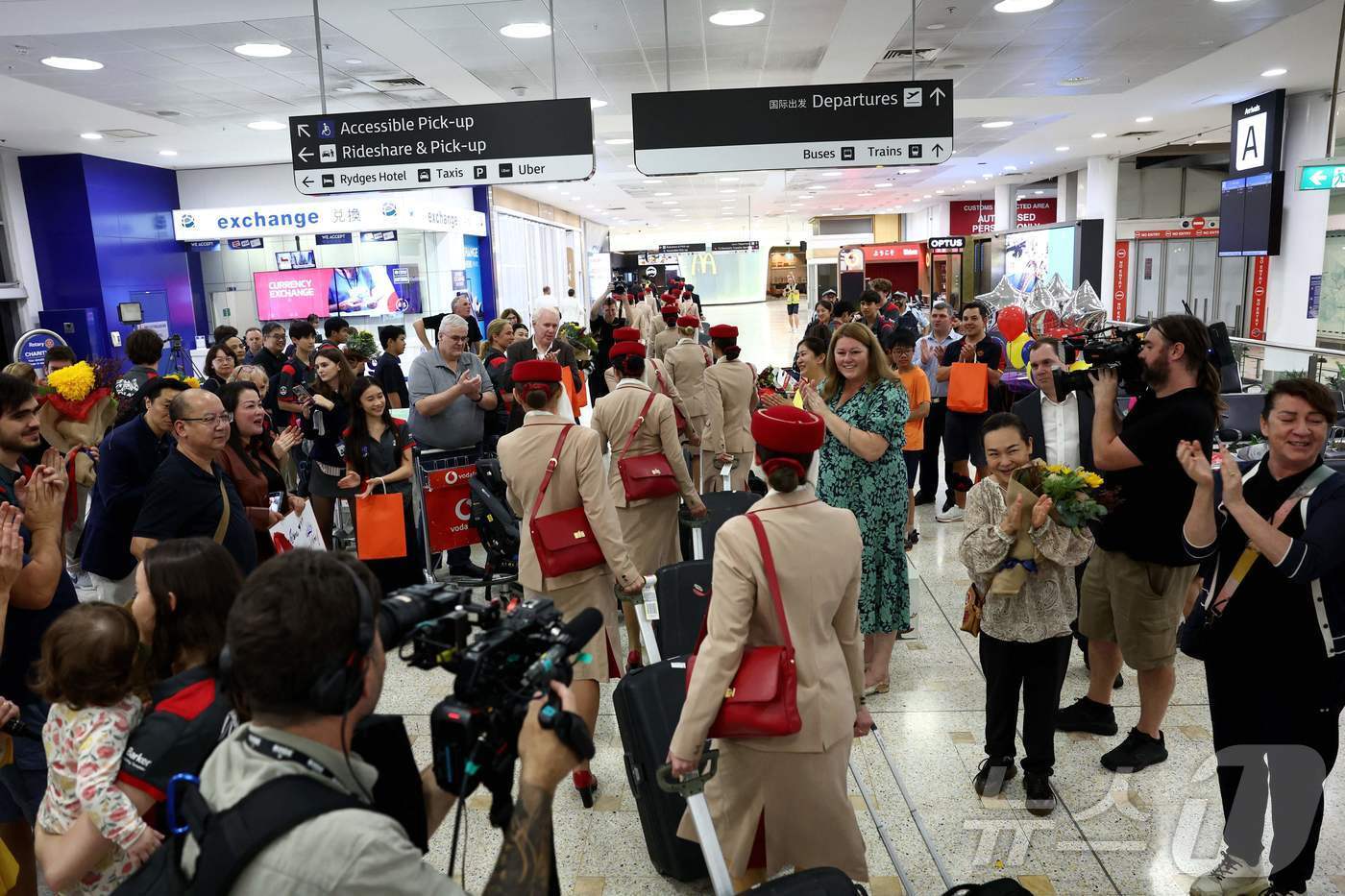 본문 이미지 - 지난 4일, 두바이발 항공편으로 시드니 킹스포드 스미스 국제공항에 도착한 에미레이트항공 승무원들을 승객들의 가족과 친구들이 환호하며 맞이하고 있다.ⓒ AFP=뉴스1