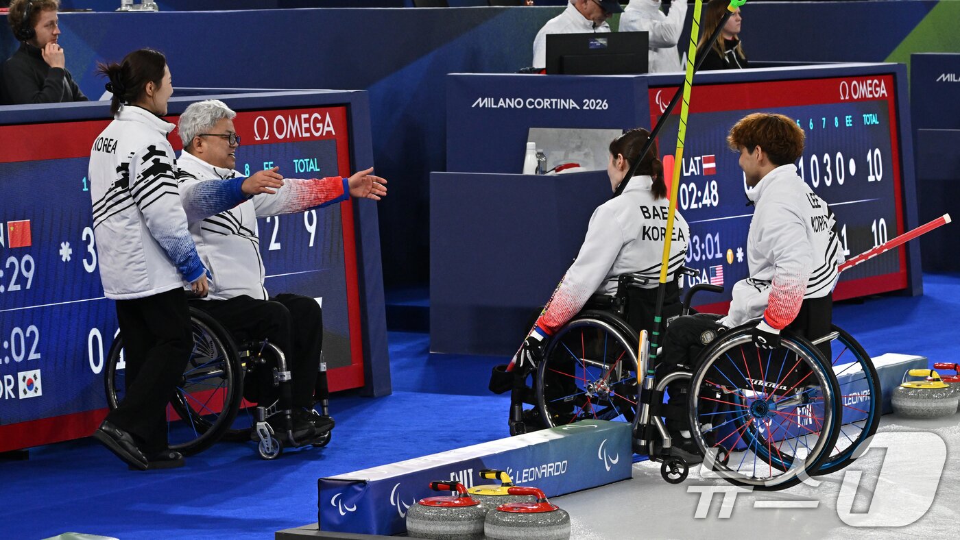 본문 이미지 - 휠체어컬링 박길우 감독(왼쪽에서 두번째)이 11일(현지시간) 이탈리아 코르티나담페초 컬링 올림픽 스타디움에서 열린 2026 밀라노 코르티나 패럴림픽 휠체어컬링 믹스더블에서 은메달을 차지한 백혜진과 이용석을 안아주고 있다. 2026.3.12 ⓒ 뉴스1 사진공동취재단