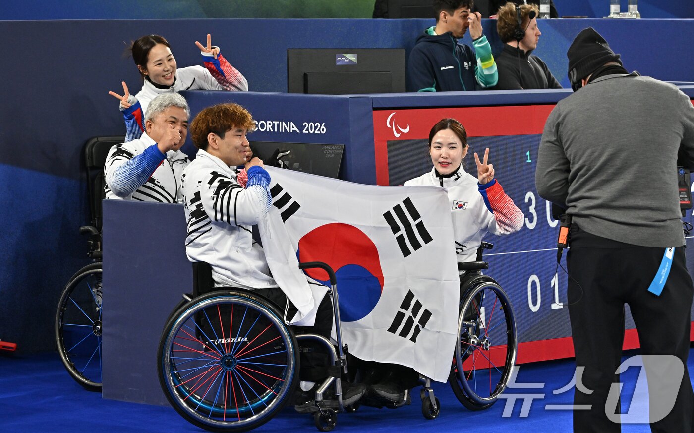 본문 이미지 - 휠체어컬링 정재이 전력분석관, 박길우 감독, 이용석, 백혜진(왼쪽부터)이 11일(현지시간) 이탈리아 코르티나담페초 컬링 올림픽 스타디움에서 열린 2026 밀라노 코르티나 패럴림픽 휠체어컬링 믹스더블에서 은메달을 차지한 뒤 태극기를 들고 포즈를 취하고 있다. 2026.3.12 ⓒ 뉴스1 사진공동취재단