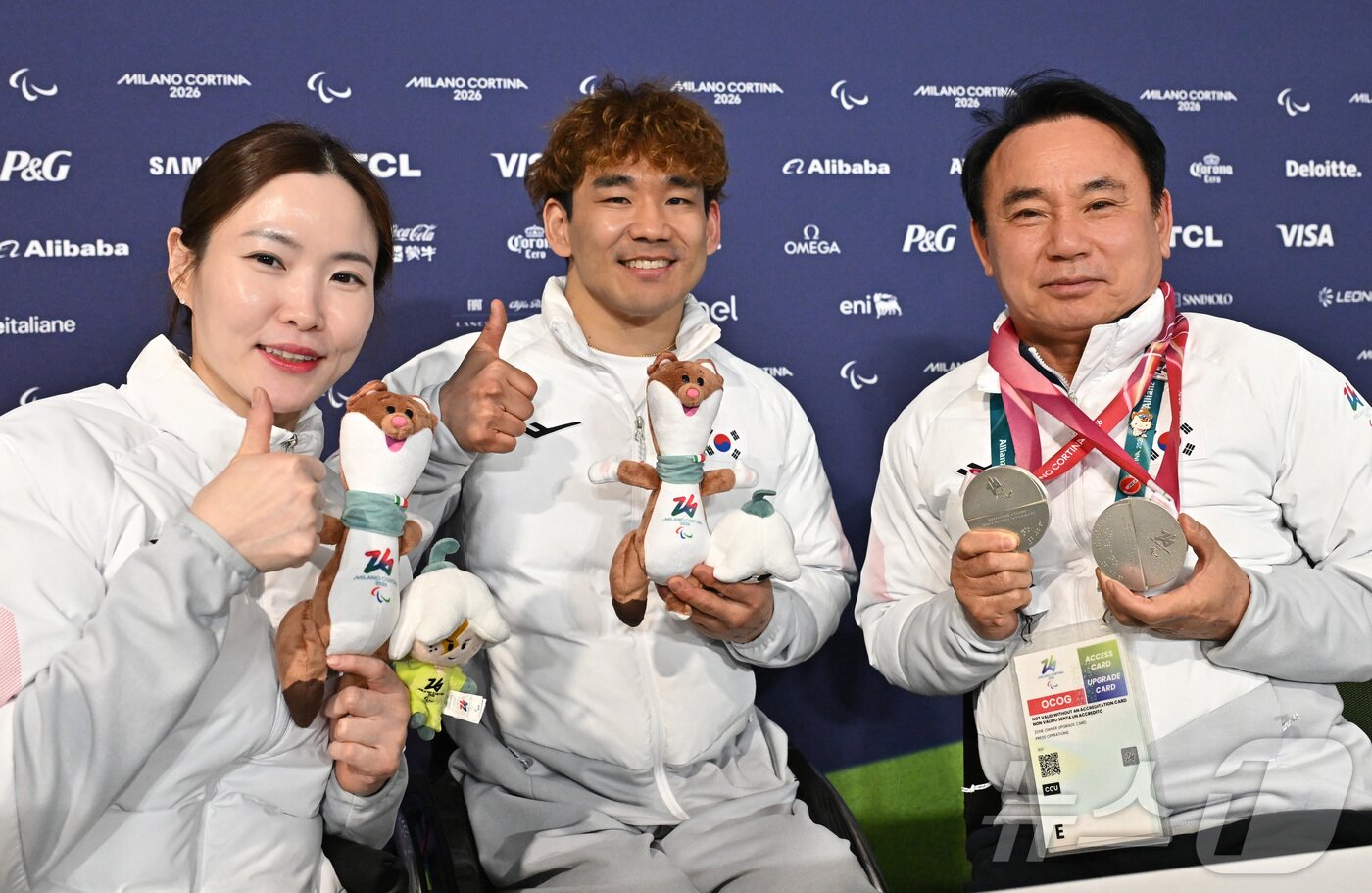 본문 이미지 - 휠체어컬링 백혜진(왼쪽)과 이용석이 11일(현지시간) 이탈리아 코르티나담페초 컬링 올림픽 스타디움에서 열린 2026 밀라노 코르티나 패럴림픽 휠체어컬링 믹스더블에서 은메달을 차지한 뒤 윤경선 대한장애인컬링협회장에게 메달을 걸어주고 기념촬영을 하고 있다. 2026.3.12 ⓒ 뉴스1 사진공동취재단