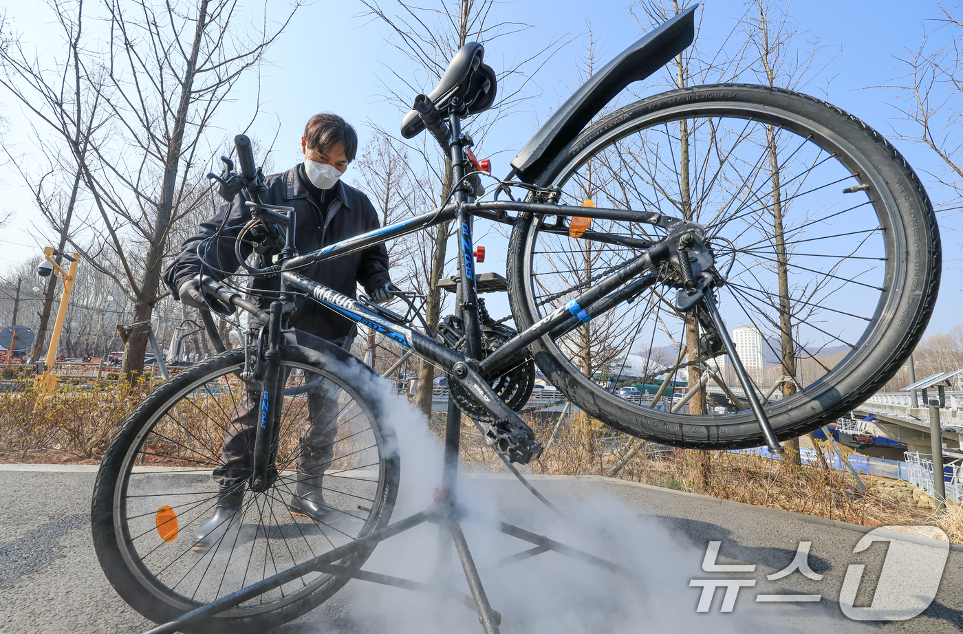 (서울=뉴스1) 이호윤 기자 = 12일 서초구 매헌시민의숲 공영주차장에서 서초구청 관계자가 봄철 자전거 스팀 세차 서비스를 하고 있다.서초구는 자전거 친화도시 조성을 위해 구민들이 …