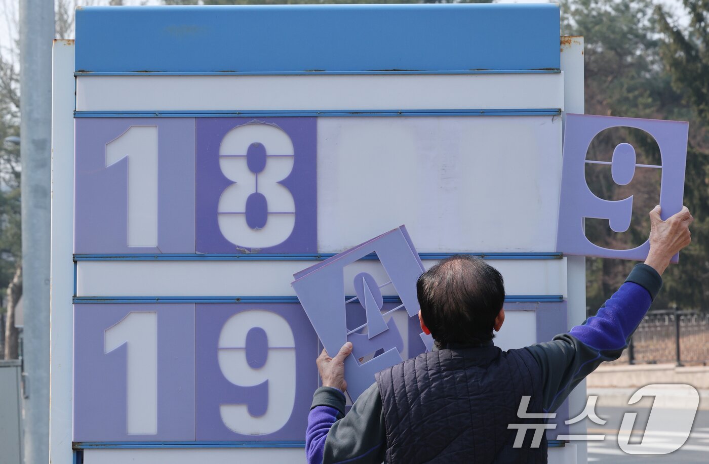 본문 이미지 - 중동 전쟁 여파로 고공행진을 이어가던 주유소 기름값이 소폭 하락한 가운데 12일 오전 대전 유성구 한 주유소에서 관계자가 휘발유와 경유 가격을 조정하고 있다. 이 주유소는 휘발유 가격을 리터당 1984원에서 1894원으로 내렸다. 2026.3.12 ⓒ 뉴스1 김기태 기자