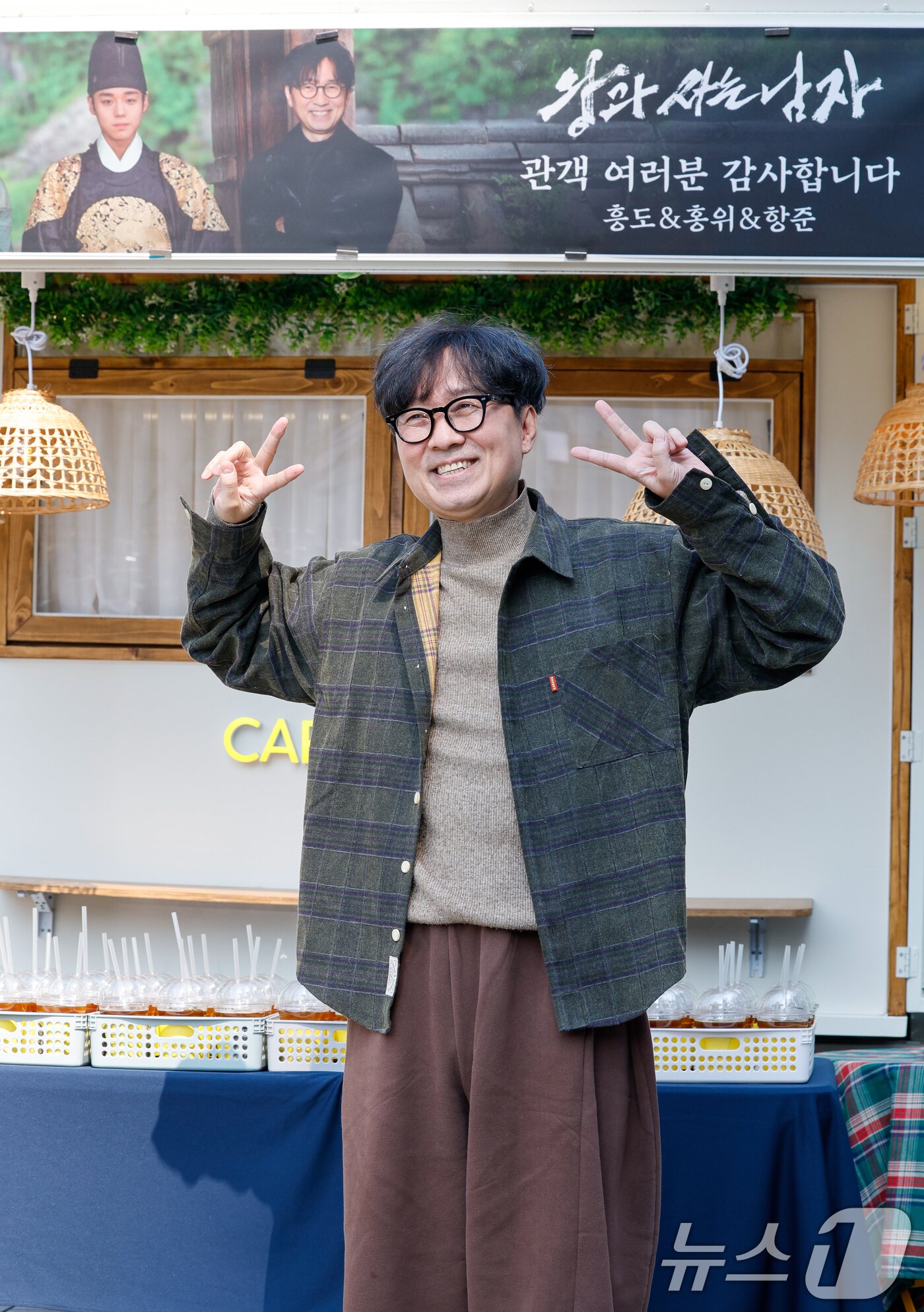 본문 이미지 - 영화 '왕과 사는 남자'의 장항준 감독이 12일 서울 중구 프레스센터 앞에서 1,200만 관객 돌파를 기념해 커피차를 마련, 팬들에게 커피를 나눠주기 전 포토타임을 갖고 있다. 2026.3.12 ⓒ 뉴스1 안은나 기자