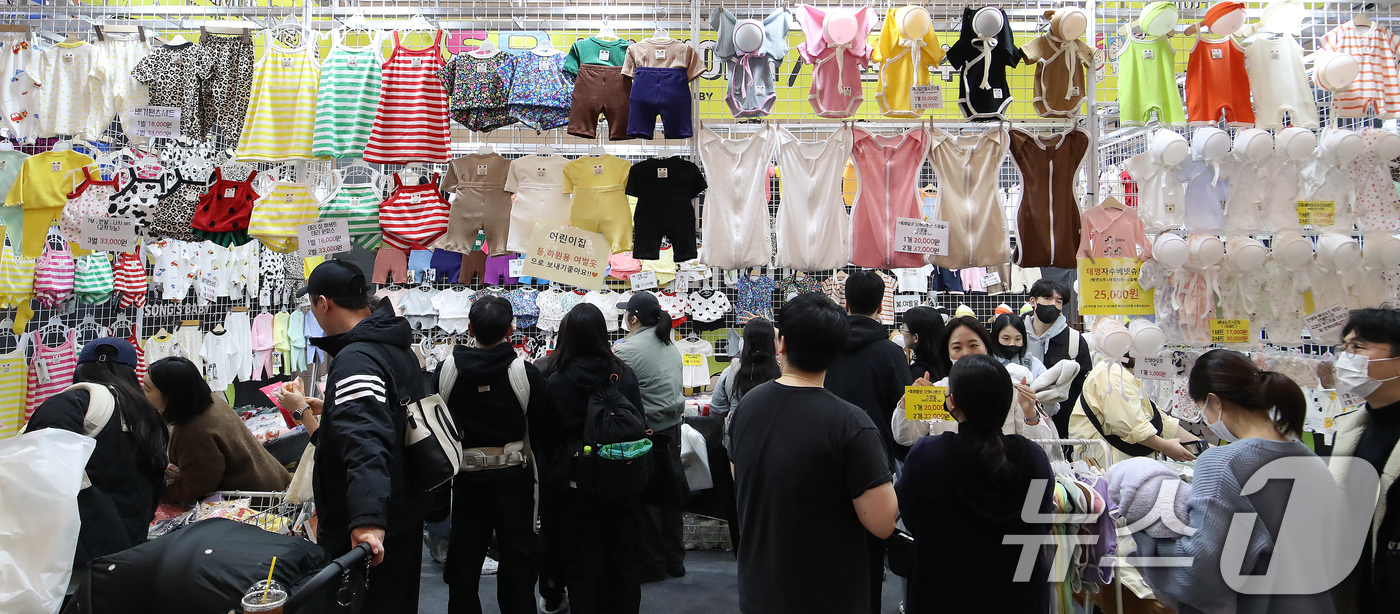 (부산=뉴스1) 윤일지 기자 = 12일 부산 해운대구 벡스코 제1전시장에서 열린 '2026 부산베이비페어'에서 관람객들이 봄을 맞아 아기 옷을 살펴보고 있다. 2026.3.12/뉴 …