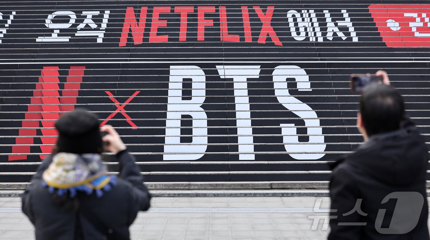 본문 이미지 - 방탄소년단(BTS)의 컴백 라이브 공연을 아흐레 앞둔 12일 서울 종로구 세종문화회관 계단에 마련된 방탄소년단 공연 홍보물 앞에서 외국인 관광객들이 사진 촬영을 하고 있다.  ⓒ 뉴스1 김성진 기자