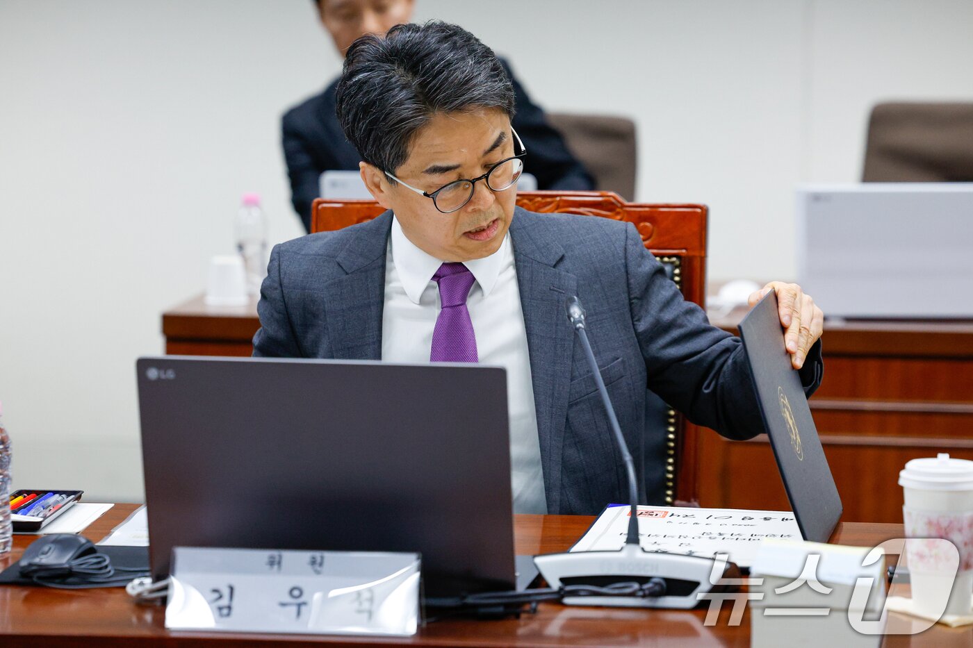 본문 이미지 - 12일 오후 서울 양천구 방송미디어통신심의위원회에서 열린 2026년 제1차 방미심위 정기 회의에서 언론노조로부터 사퇴 압박을 받고 있는 김우석 상임위원이 위촉장을 들여다보고 있다. 2026.3.12 ⓒ 뉴스1 안은나 기자