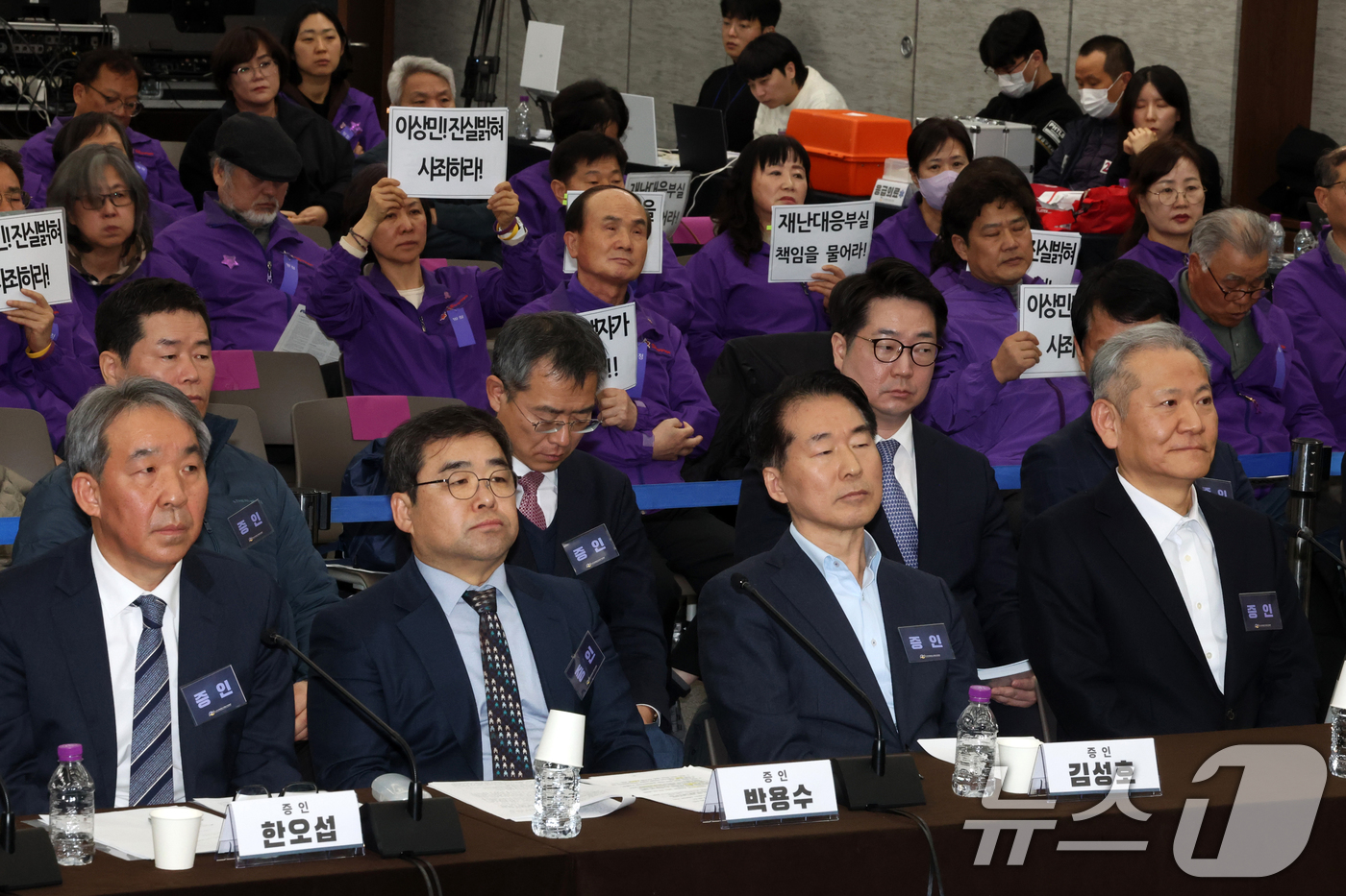 (서울=뉴스1) 최지환 기자 = 이상민 전 행정안전부 장관이 12일 오후 서울 중구 은행회관에서 열린 10·29이태원참사 진상규명 청문회에 참석한 가운데 유가족들이 손팻말을 들고 …