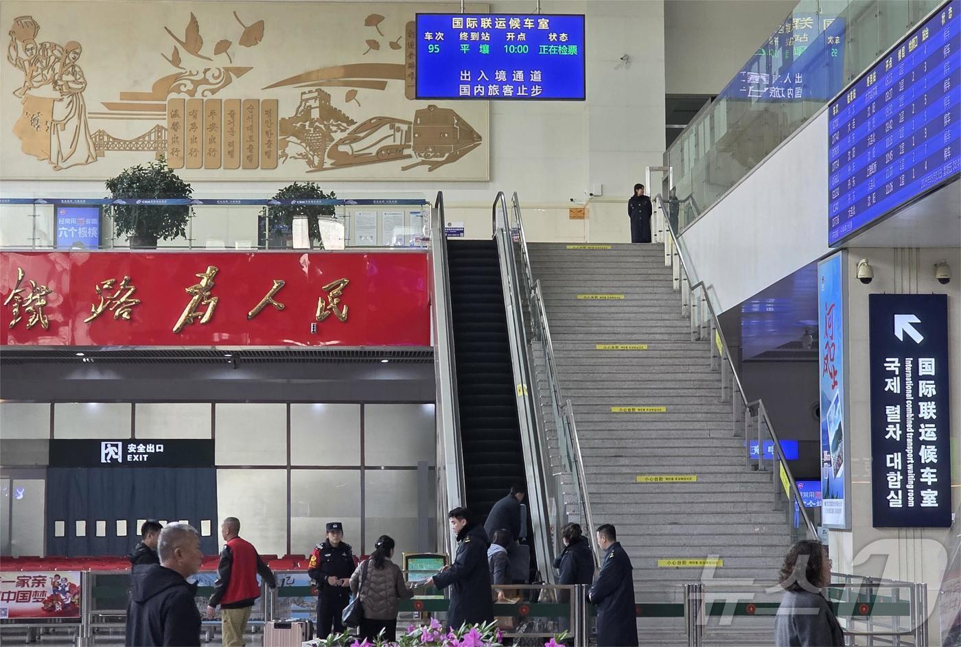 본문 이미지 - 13일 오전 중국 랴오닝성 단둥시 단둥역 국제 여객 대합실에 평양행 열차에 탑승하려는 북한 주민들이 여권을 제시하며 탑승 수속을 밟고 있다. 전일 저녁 베이징을 출발해 이날 오전 단둥역에 도착한 평양행 열차는 이날 오전 10시 출발 예정이다. 2026.3.13