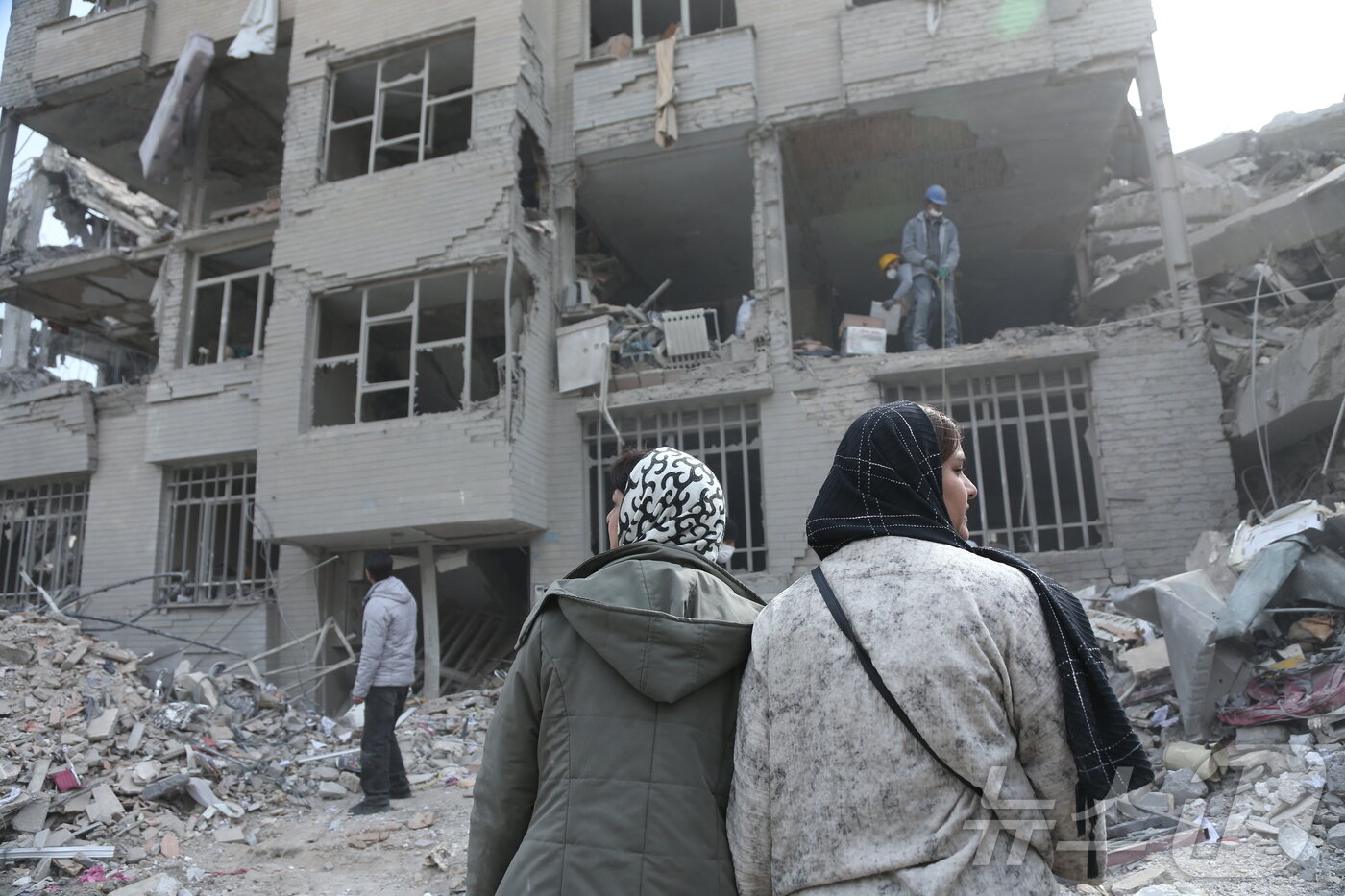 본문 이미지 - 12일(현지시간) 이란 수도 테헤란의 폐허 속에서 주민들이 폭격에 손상된 건물을 뒤져 생필품을 찾고 있다. 2026.3.12 ⓒ 신화=뉴스1