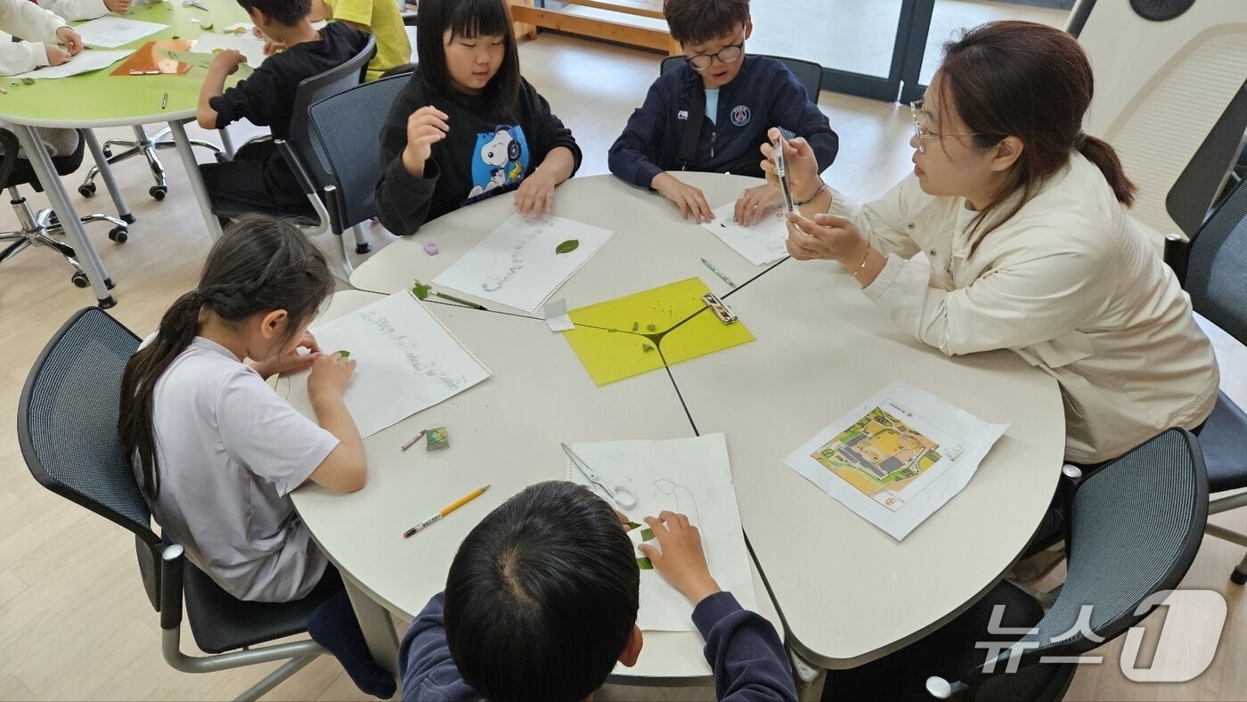 본문 이미지 - 송산초 학생들이 선생님과 함께 학교 숲 생태지도 그리기를 하고 있다.(전남교육청 제공, 재판매 및.DB 금지)/뉴스1  