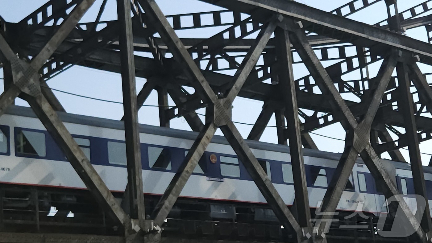 (단둥=뉴스1) 정은지 특파원 = 13일 오전 10시 단둥역을 출발한 국제 여객 열차가 압록강철교를 지나고 있다. 파란색 열차는 전일 오후 베이징에서 출발한 열차다. 2025.3. …