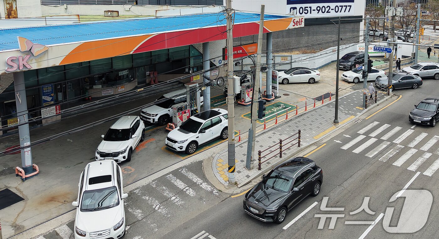 본문 이미지 - 석유제품 최고가격제 시행 첫날인 13일 휘발유 가격이 1757원으로 부산지역에서 가장 저렴한 해운대구 한 주유소에서 차량들이 주유를 하기 위해 줄지어 대기하고 있다. 2026.3.13 ⓒ 뉴스1 윤일지 기자