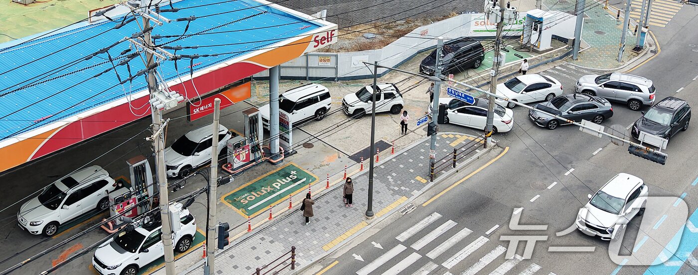 본문 이미지 - 석유제품 최고가격제 시행 첫날인 13일 휘발유 가격이 1757원으로 부산지역에서 가장 저렴한 해운대구 한 주유소에서 차량들이 주유를 하기 위해 줄지어 대기하고 있다. 2026.3.13 ⓒ 뉴스1 윤일지 기자