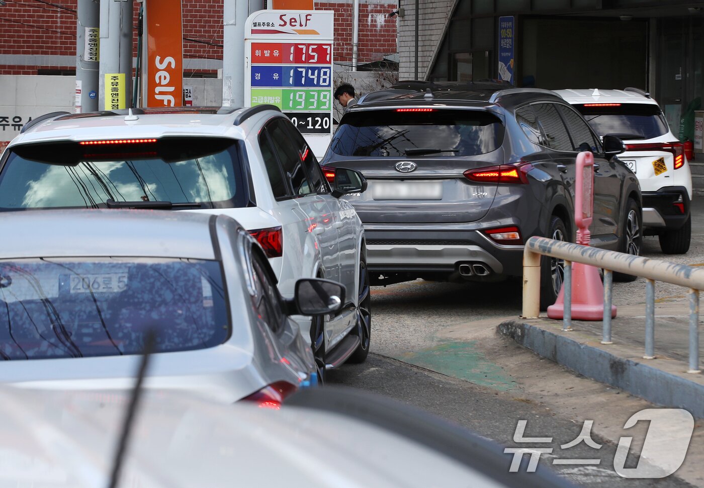 본문 이미지 - 석유제품 최고가격제 시행 첫날인 13일 휘발유 가격이 1757원으로 부산지역에서 가장 저렴한 해운대구 한 주유소에서 차량들이 주유를 하기 위해 줄지어 대기하고 있다. 2026.3.13 ⓒ 뉴스1 윤일지 기자
