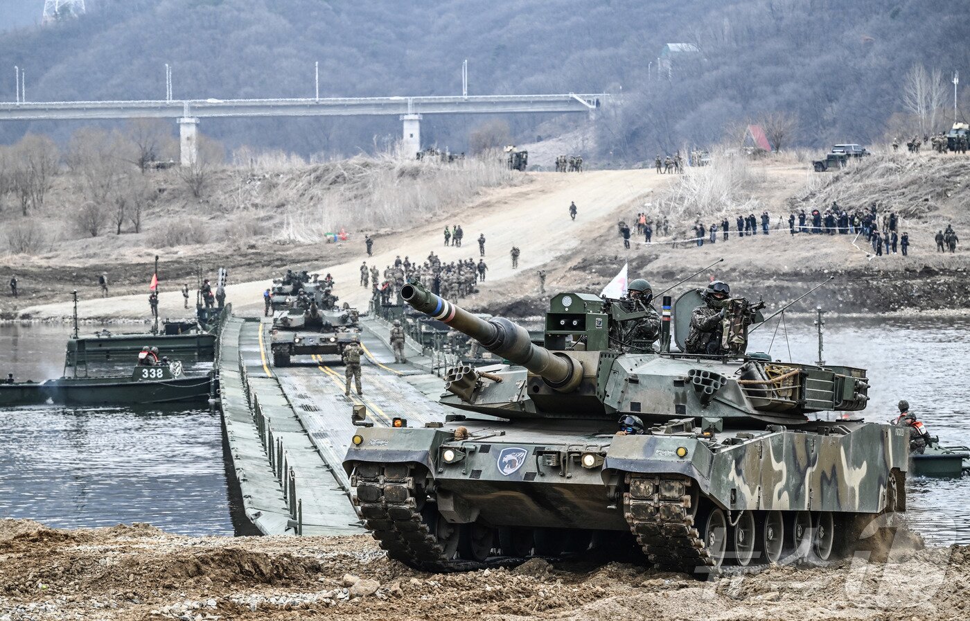 본문 이미지 - 14일 경기도 연천군 일대에서 실시된 한미연합 제병협동훈련에서 K1A2 전차가 한국군 자주도하장비 수룡(KM3)과 미국 개량형 전술부교(IRB)가 결합한 연합부교를 통해 도하하고 있다. (육군 제공. 재판매 및 DB 금지) 2026.3.14 ⓒ 뉴스1