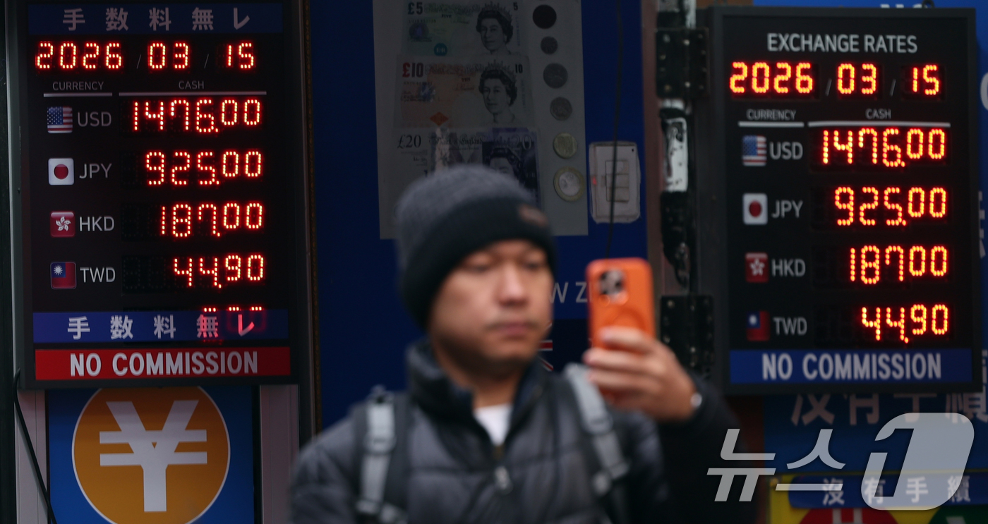 (서울=뉴스1) 황기선 기자 = 중동 상황 악화로 원·달러 환율이 오름세를 보이고 있는 15일 서울 중구 명동의 한 환전소 앞 전광판에 환율이 표시되고 있다. 2026.3.15/뉴 …