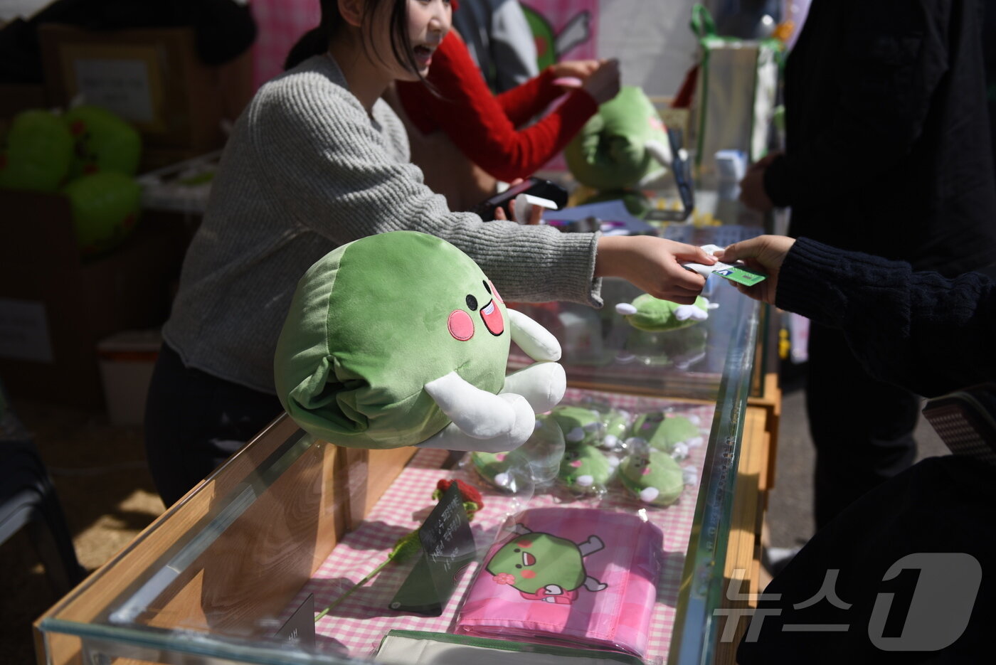 본문 이미지 - 15일 광양매화축제장을 찾은 관광객이 매돌이 굿즈를 구매하고 있다. ⓒ 뉴스1 김성준 기자