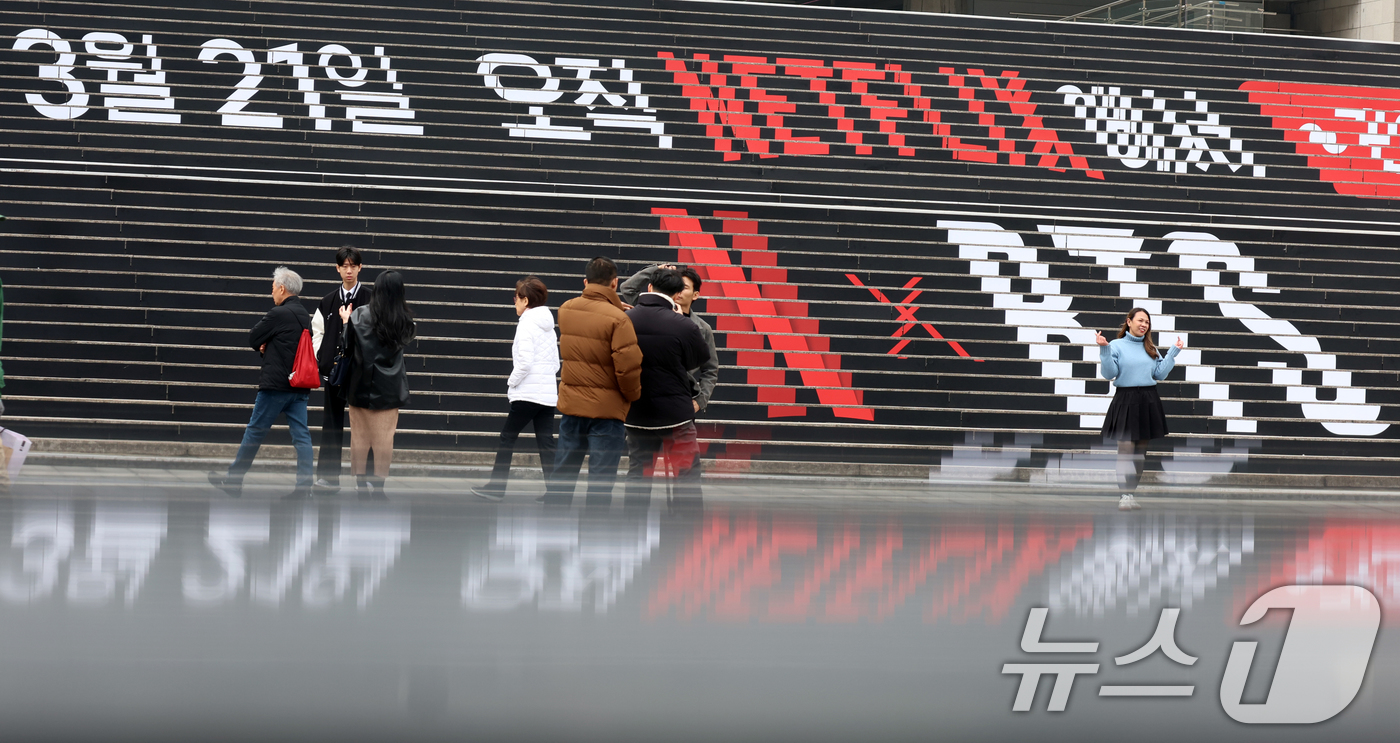 (서울=뉴스1) 김명섭 기자 = 15일 서울 종로구 세종문화회관 계단에 마련된 방탄소년단(BTS)의 컴백 라이브 공연 홍보물 앞에서 외국인 관광객이 기념촬영을 하고 있다. 약 3년 …