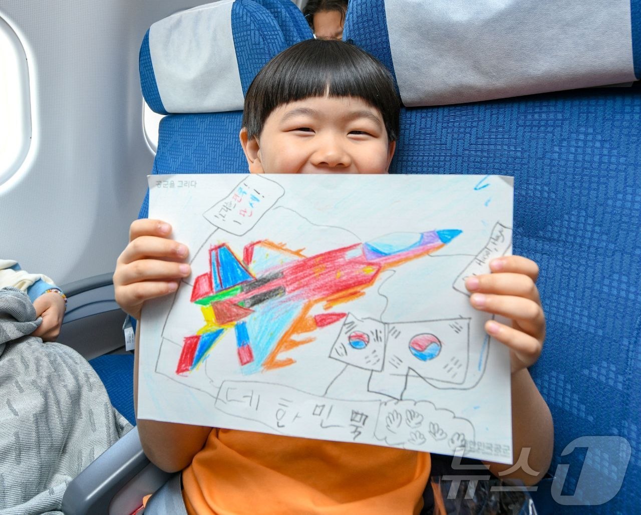 (서울=뉴스1) = 15일 사우디를 출발하는 공군 수송기(KC-330)에 탑승한 어린아이가 스케치북으로 그림을 그리고 있다. (국방부 제공. 재판매 및 DB 금지)  2026.3. …