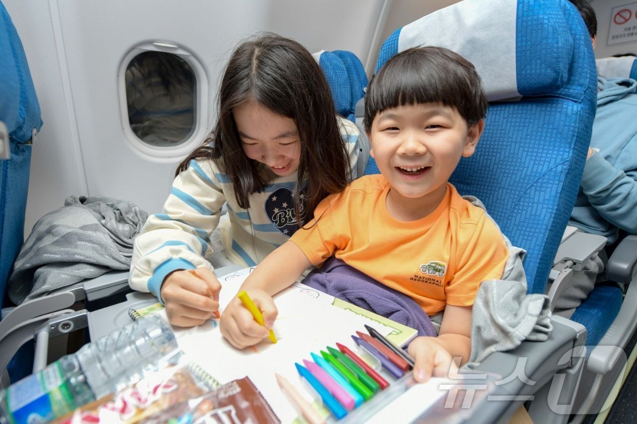 (서울=뉴스1) = 15일 사우디를 출발하는 공군 수송기(KC-330)에 탑승한 어린아이가 스케치북으로 그림을 그리고 있다. (국방부 제공. 재판매 및 DB 금지)  2026.3. …