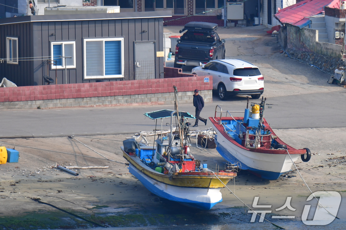 (영덕=뉴스1) 최창호 기자 = 16일 오전 경북 영덕군 영덕읍 노물리 해안 마을에서 주민이 아침 조업을 준비하기 위해 걸어가고 있다.  2026.3.16/뉴스1
