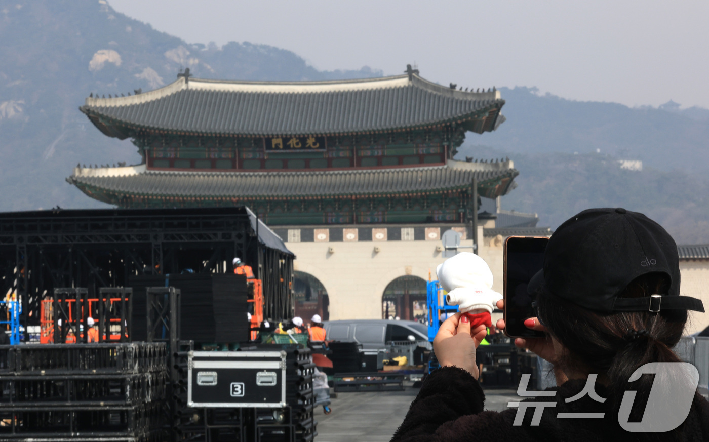 (서울=뉴스1) 임세영 기자 = 16일 서울 광화문장에 설치되고 있는 방탄소년단(BTS)의 컴백 라이브 공연 무대 앞에서 한 외국인 팬이 기념촬영을 하고 있다.약 3년 9개월 만에 …