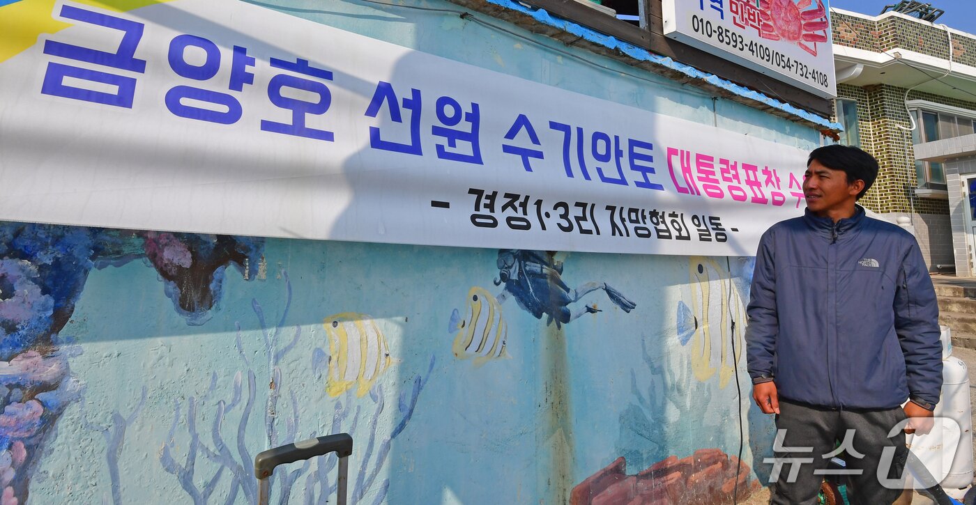 본문 이미지 - 인도네시아 국적의 수기안토 씨(32)가 16일 경북 영덕군 영덕읍 경정3리에 있는 자신의 숙소 앞에 걸려 있는 축하 현수막을 바라보고 있다. 2026.3.16/뉴스1 최창호 기자  