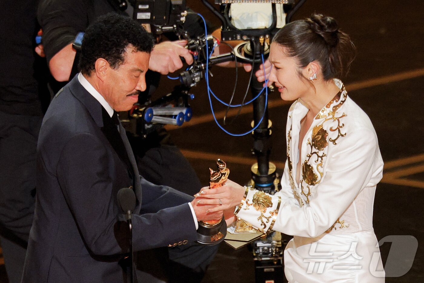 본문 이미지 - 15일(현지시간) 미국 캘리포니아주 로스앤젤레스 할리우드에서 열린 제98회 아카데미 시상식에서 라이오넬 리치가 이재에게 상을 수여하고 있다. 이날 'K팝 데몬 헌터스'는 제98회 아카데미 시상식에서 주제곡 '골든'으로 최우수 주제가 상을 수상했다. ⓒ 로이터=뉴스1