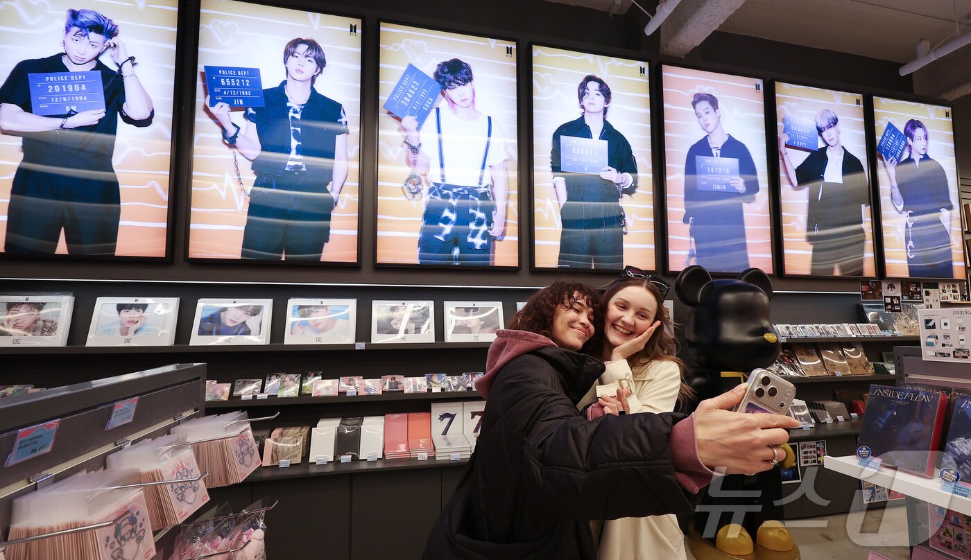 본문 이미지 - 방탄소년단(BTS)의 컴백 공연을 닷새 앞둔 16일 서울 명동의 한 K팝 굿즈 판매점에서 외국인 팬들이 셀피 촬영을 하고 있다. 약 3년 9개월 만에 컴백하는 방탄소년단(BTS)의 공연은 오는 21일 오후 8시 광화문광장에서 ‘BTS 컴백 라이브: 아리랑(ARIRANG)’이라는 타이틀로 개최된다. 2026.3.16 ⓒ 뉴스1 김성진 기자