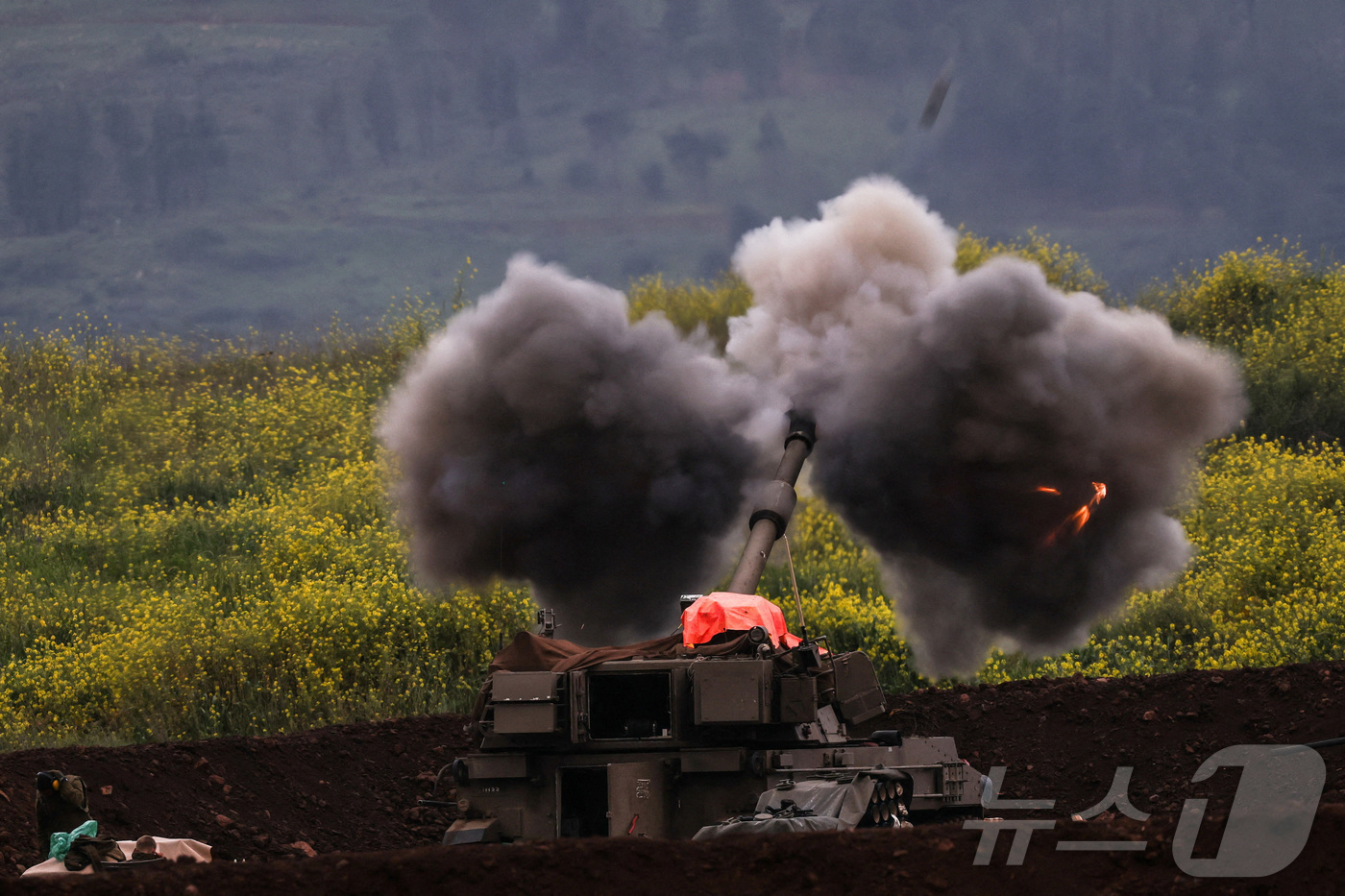 (로이터=뉴스1) 김지완 기자 = 15일(현지시간) 이스라엘군의 한 포병 부대가 이스라엘 북부 레바논 접경 지역에서 포격을 하고 있다. 2026.03.15ⓒ 로이터=뉴스1