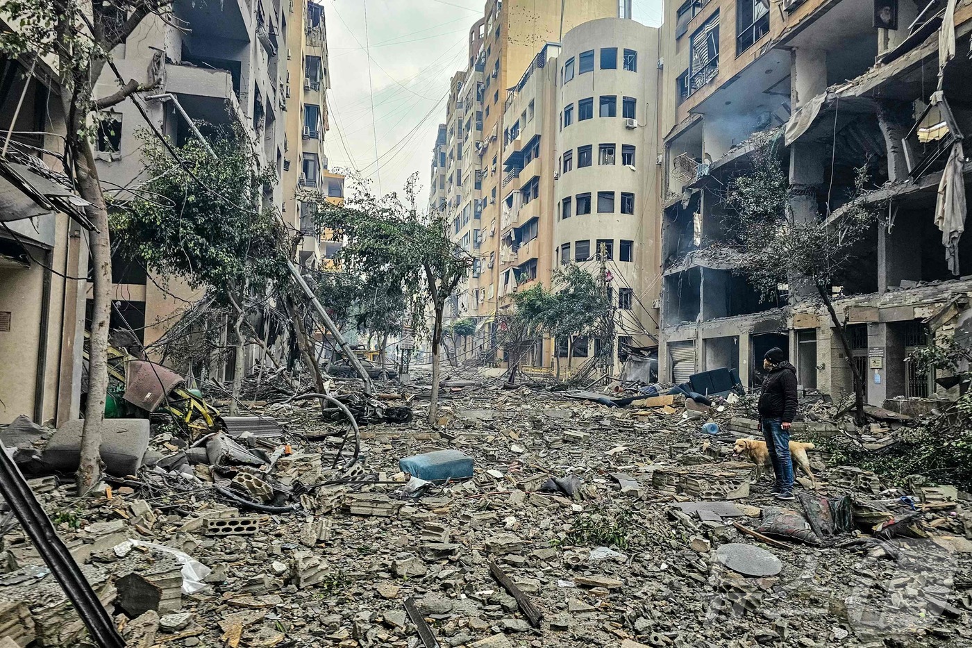 (베이루트 AFP=뉴스1) 권영미 기자 = 2026년 3월 15일 레바논 베이루트 남부 교외 하레트 흐레이크에서 이스라엘 공습으로 파괴된 건물 잔해 위를 한 남성과 그의 반려견이 …