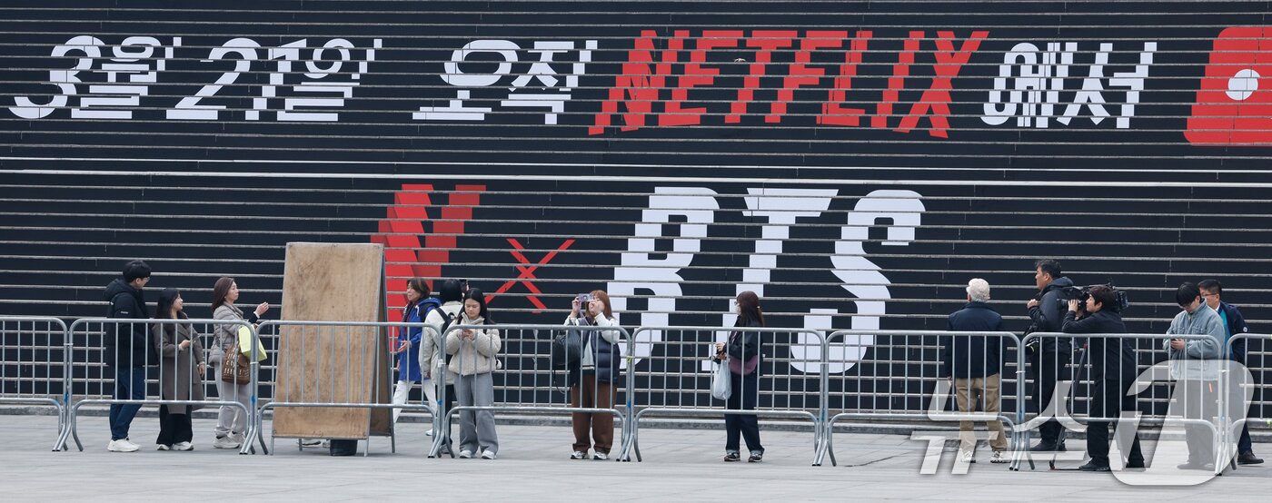 본문 이미지 - BTS(방탄소년단) 컴백 라이브 ARIRANG(아리랑)을 앞둔 16일 서울 종로구 광화문 광장이 무대 설치로 통제된 가운데 팬들이 이를 촬영하고 있다. 2026.3.16 ⓒ 뉴스1 안은나 기자